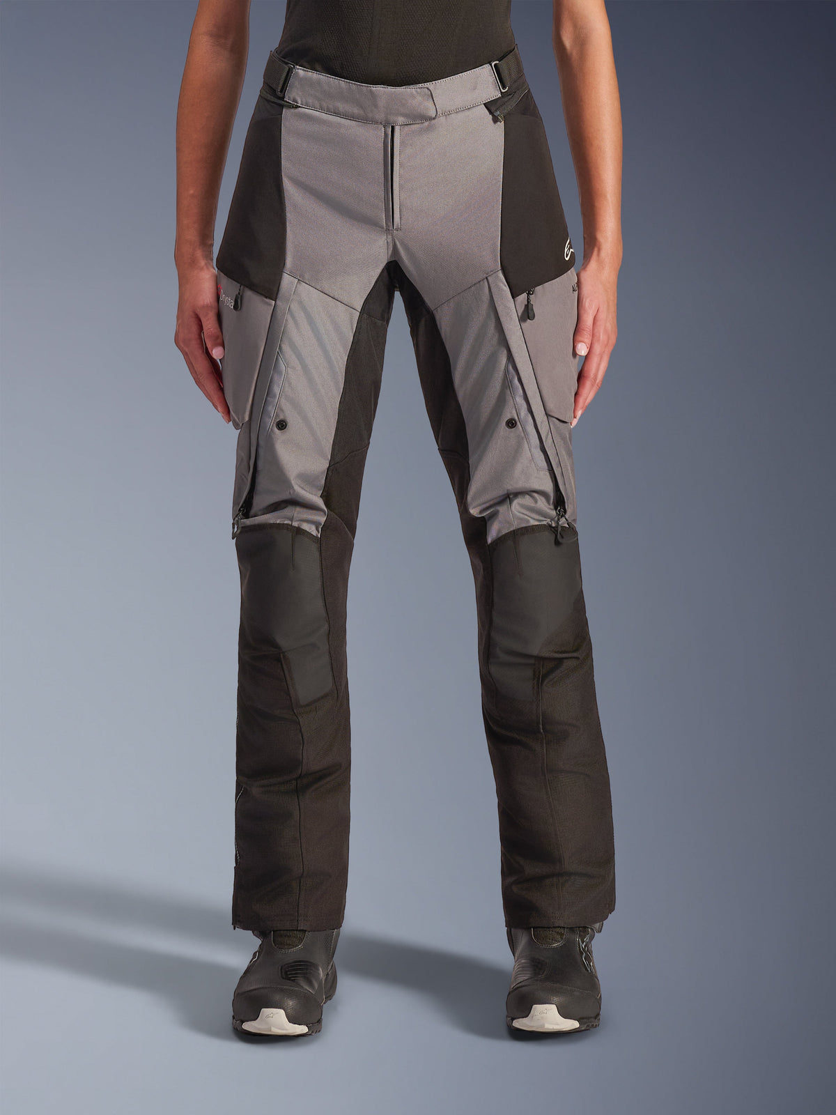 Alpinestars Stella Andes V4 Drystar, pantalon de moto touring pour femme, gris et noir, vue de face montrant les aérations zippées sur les cuisses, les poches cargo et les sections de genoux renforcées, conçu pour la conduite d'aventure par tous les temps
