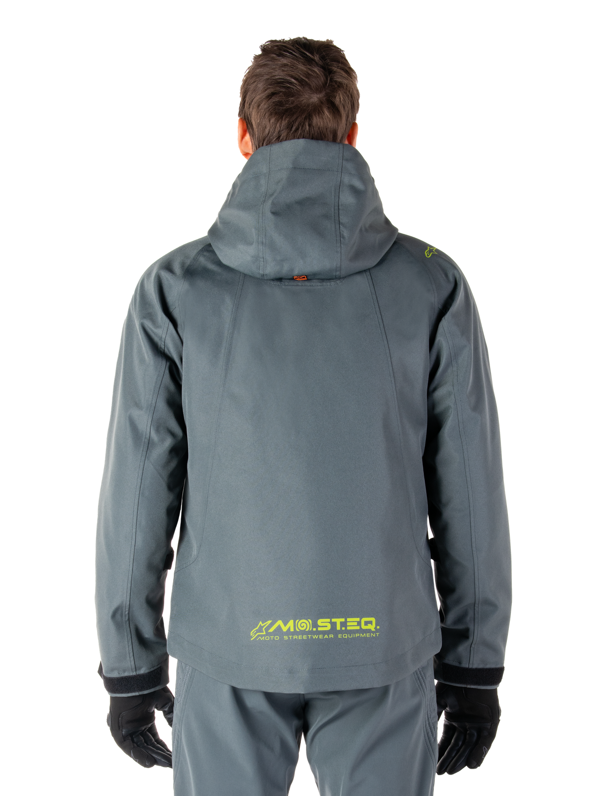 Parka imperméable Alpinestars Morush, veste de moto, gris urbain, vue arrière montrant la capuche et le logo MO.ST.EQ. jaune en bas du dos, équipement de moto moderne inspiré du streetwear urbain