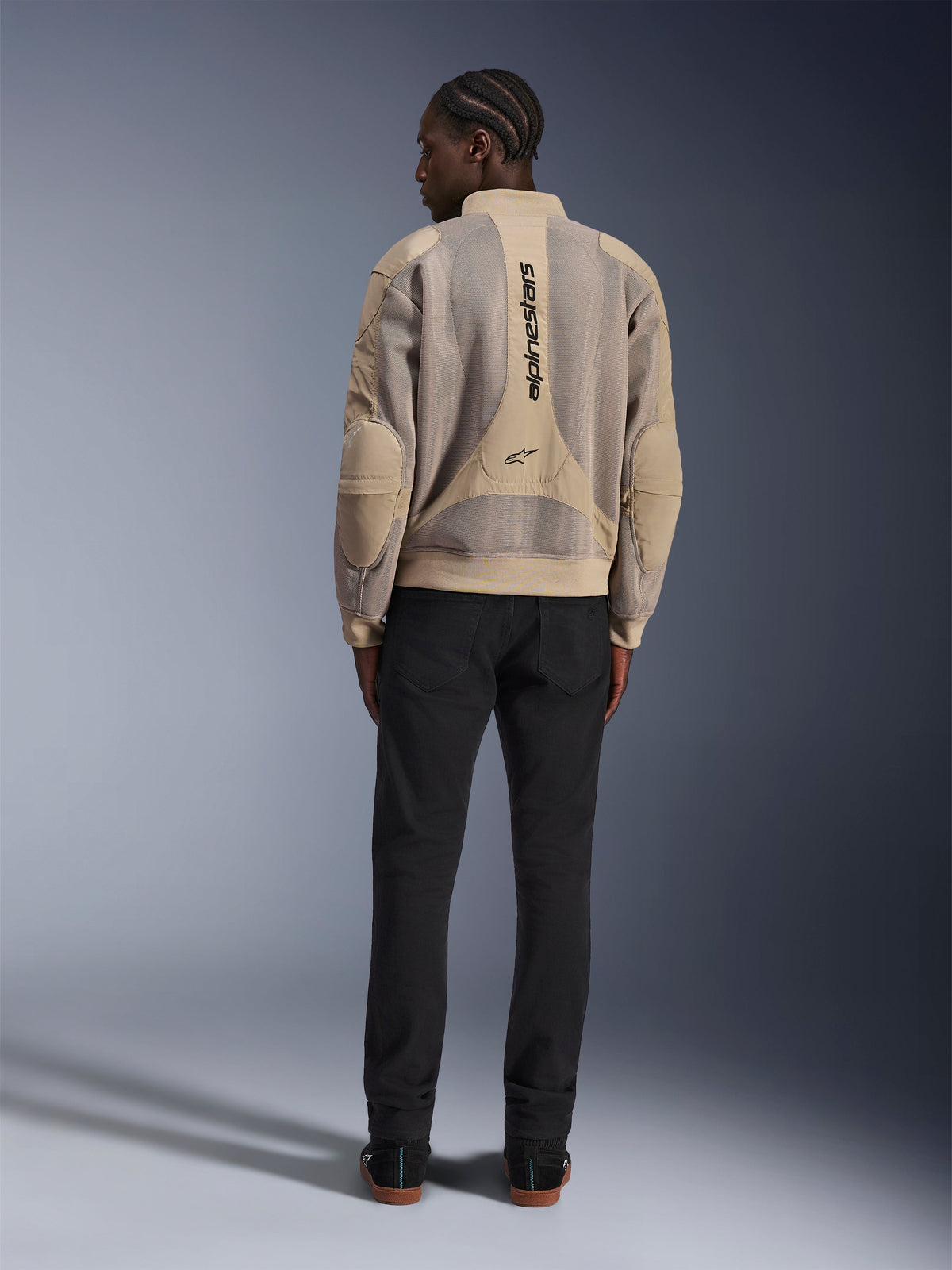 Alpinestars Flight Air Jacket, Tan urban motorcycle jacket, rear view showing breathable 3D mesh panels and vertical logo, worn with black pants for a modern street-style look
