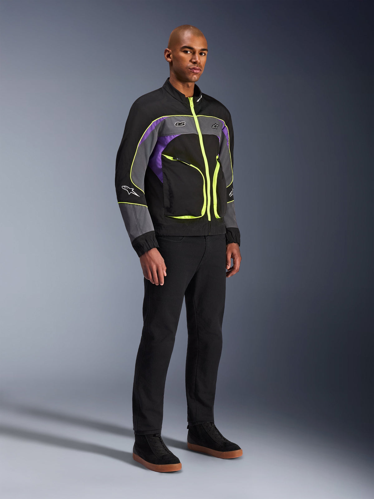 Alpinestars Unite Jacket, urban motorcycle jacket, Black Asphalt Violet with neon yellow accents, worn by model with black pants and sneakers, contemporary streetwear style for urban riding