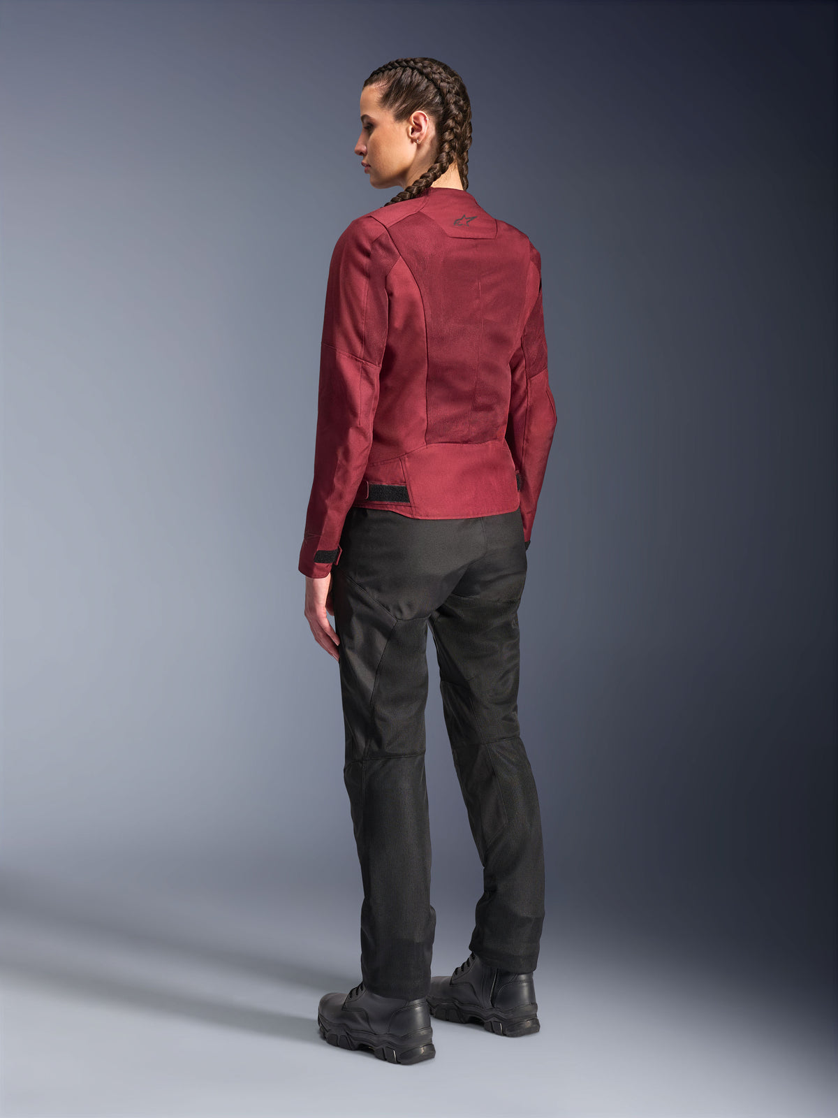 Female rider wearing Alpinestars Stella C-1 Air Jacket in burgundy and Stella C-1 Air Pants in black, full-length back view, urban motorcycle gear featuring technical mesh panels, paired with black riding boots