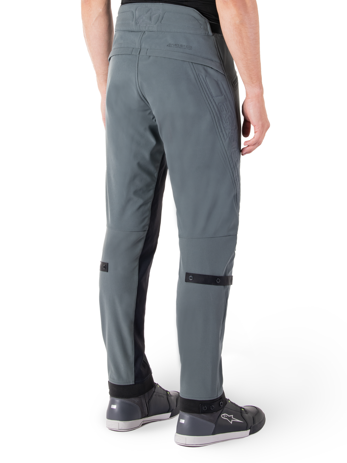 Pantalon Alpinestars Alden, Gris Urbain, vue latérale arrière, pantalon de moto technique d'inspiration streetwear avec détails matelassés à la taille et sangles noires aux mollets, associé à des chaussures de moto grises, équipement de moto urbain moderne