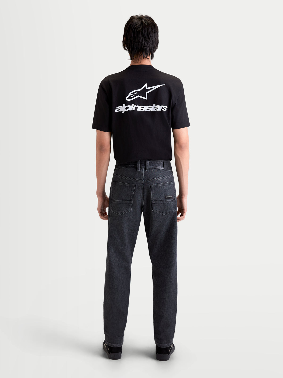 Alpinestars Flex-AST 7 Denim Pantalons, pantalon de moto urbain pour homme en noir délavé, vue de dos montrant la construction en denim technique et la disposition à cinq poches porté par un modèle