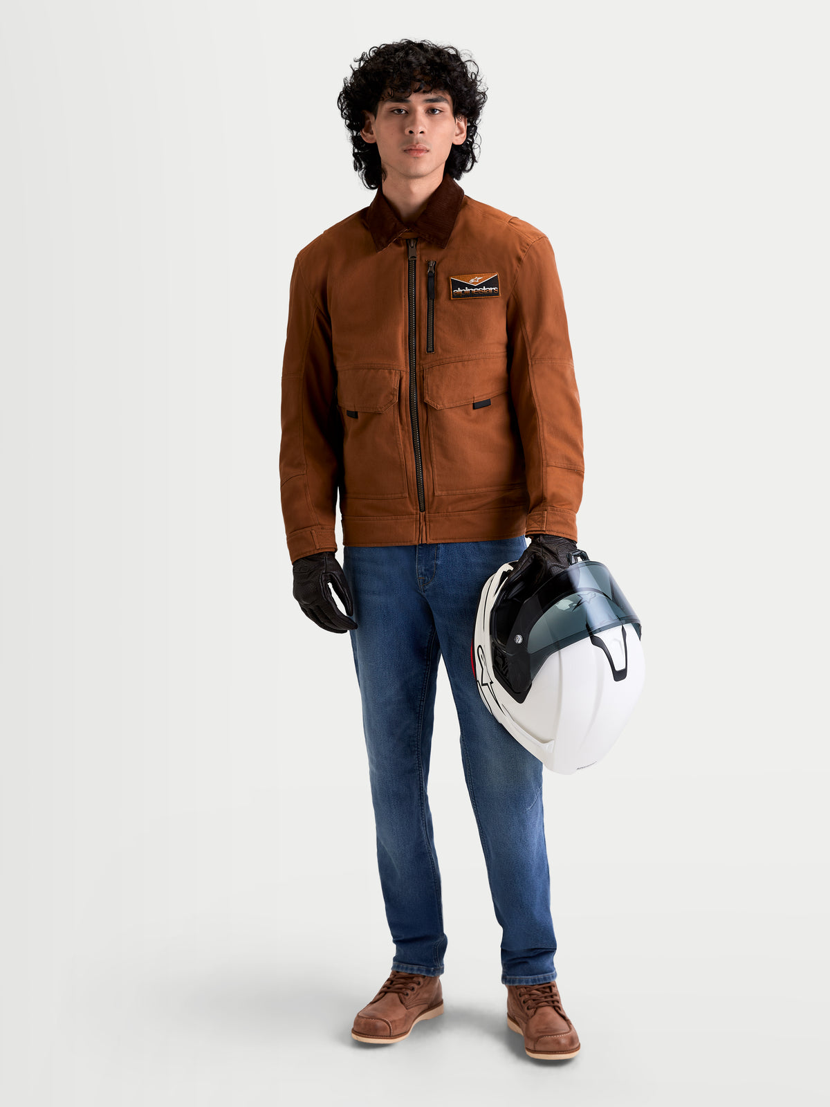 Alpinestars Flex-AST 7 Denim Pantalons, pantalon de moto urbain pour homme en bleu clair, porté par un modèle tenant un casque et une veste assortie