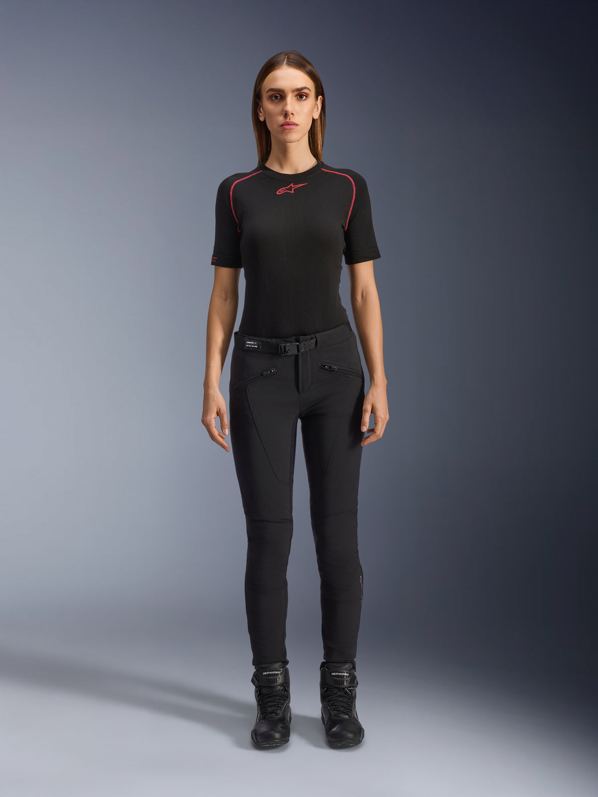 Pantalon Alamosa pour femme Alpinestars, pantalon de moto noir coupe slim, porté par un mannequin de face, doté de poches avant zippées et d'une ceinture intégrée, style minimaliste inspiré du streetwear pour la conduite urbaine