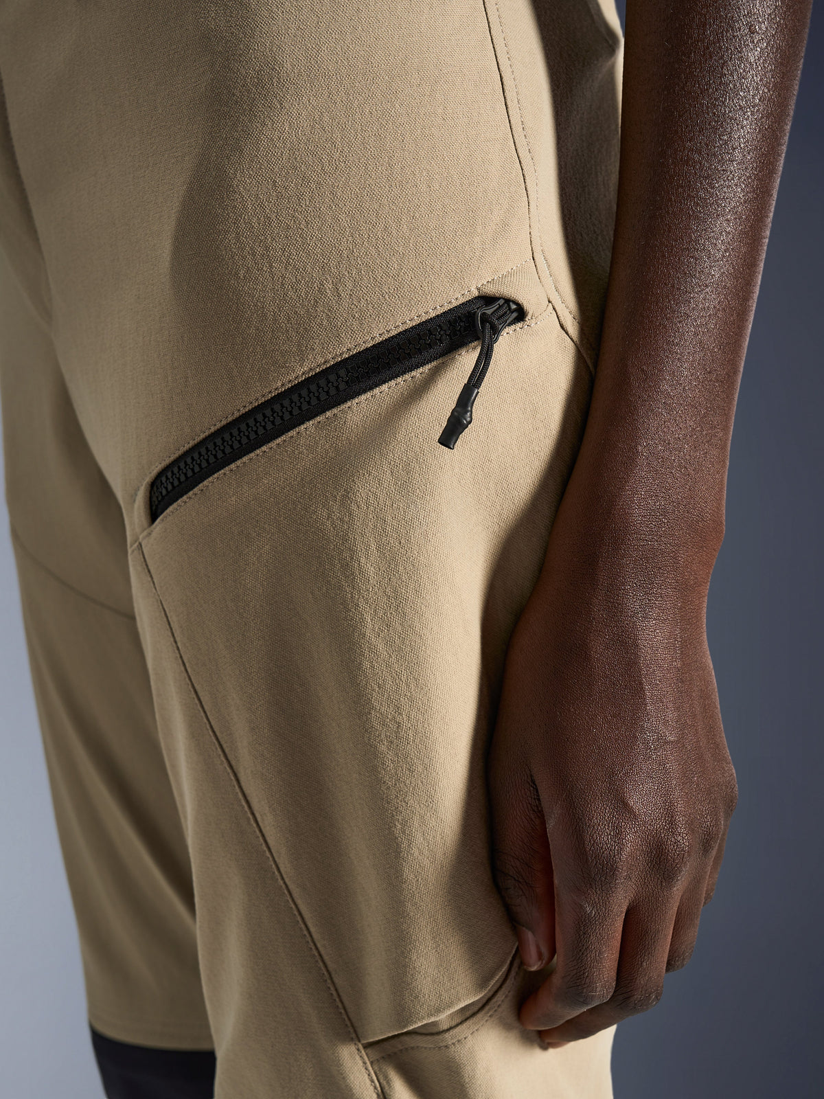 Pantalon pour femme Alpinestars Stella Flex-AST Explorer en coloris Sable, gros plan sur la zone de la hanche et de la cuisse présentant une poche cargo zippée diagonale noire et un tissu textile ripstop résistant.