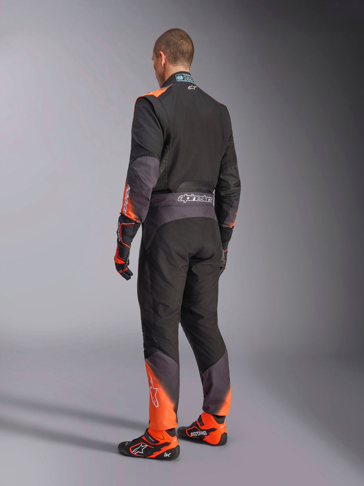 Alpinestars KMX-5 V3, combinaison de karting pour homme, noire et orange, certifiée FIA 8877-2022 grade 1, vue de dos.