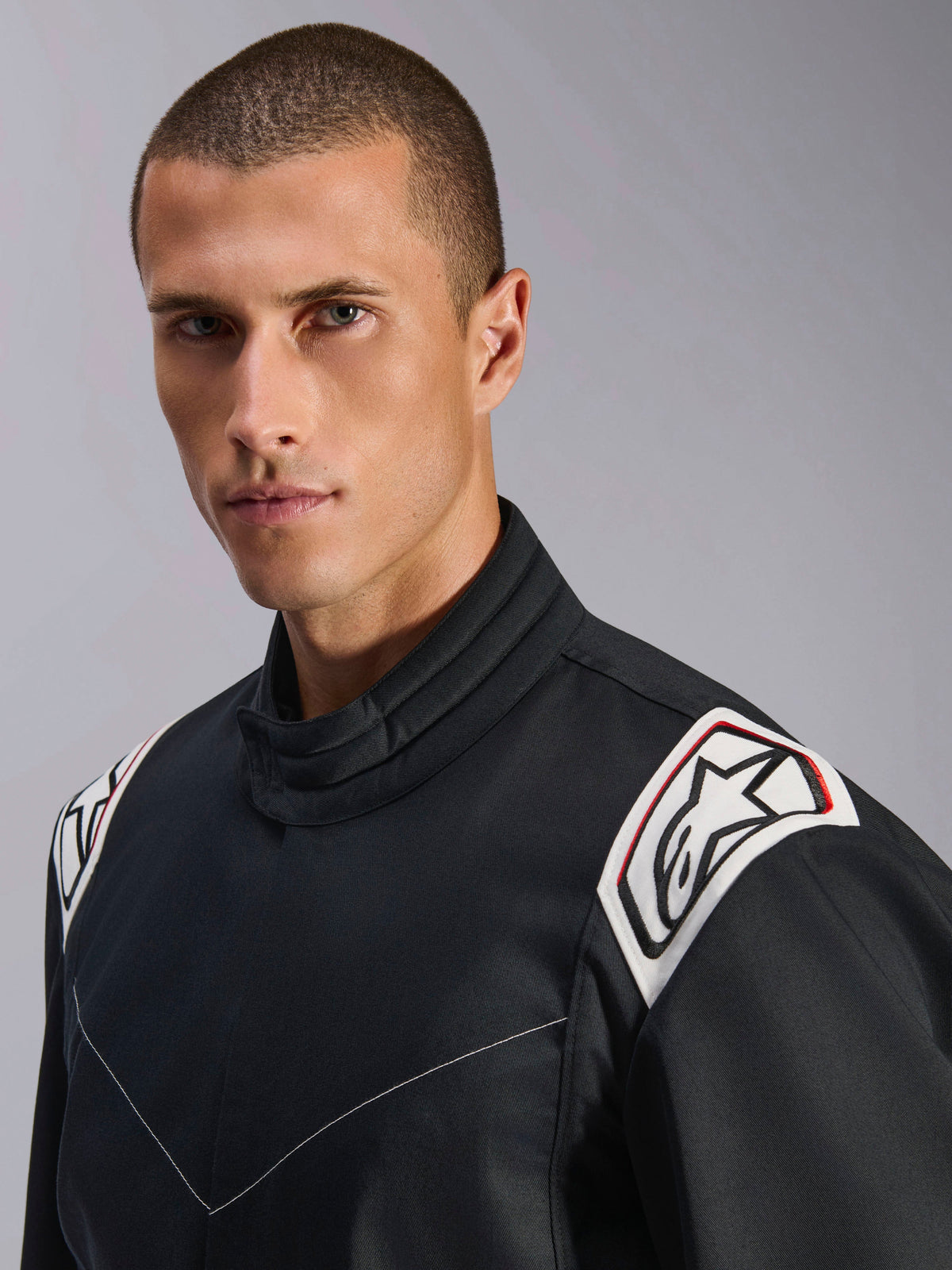 Combinaison Alpinestars Kart Indoor V2, noire, vue rapprochée des épaules et du col, épaulettes blanches avec logo Astars noir, design de col ergonomique, construction en sergé poly-coton durable pour le karting indoor