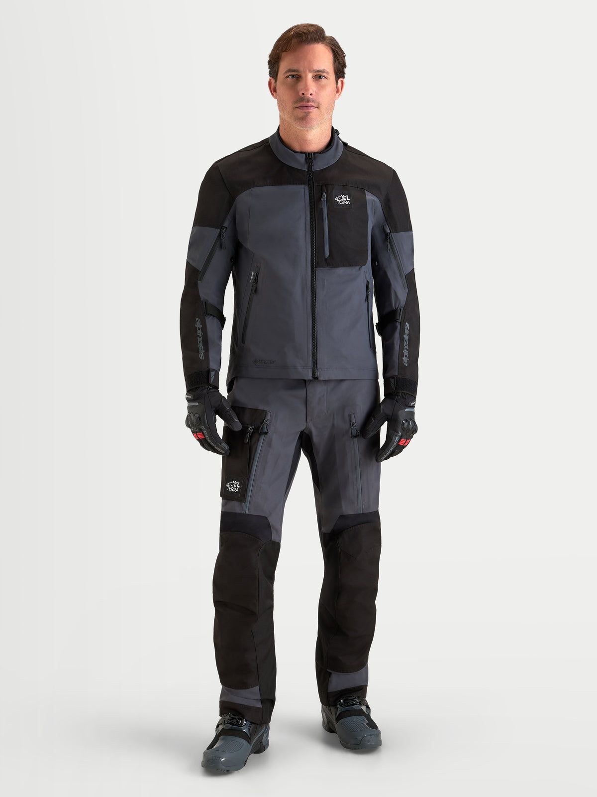 Alpinestars Arenis Gore-Tex® Tenue complète, veste et pantalon de moto adventure pour homme en noir et gris foncé, vue de face complète sur un modèle portant un équipement d'équitation imperméable