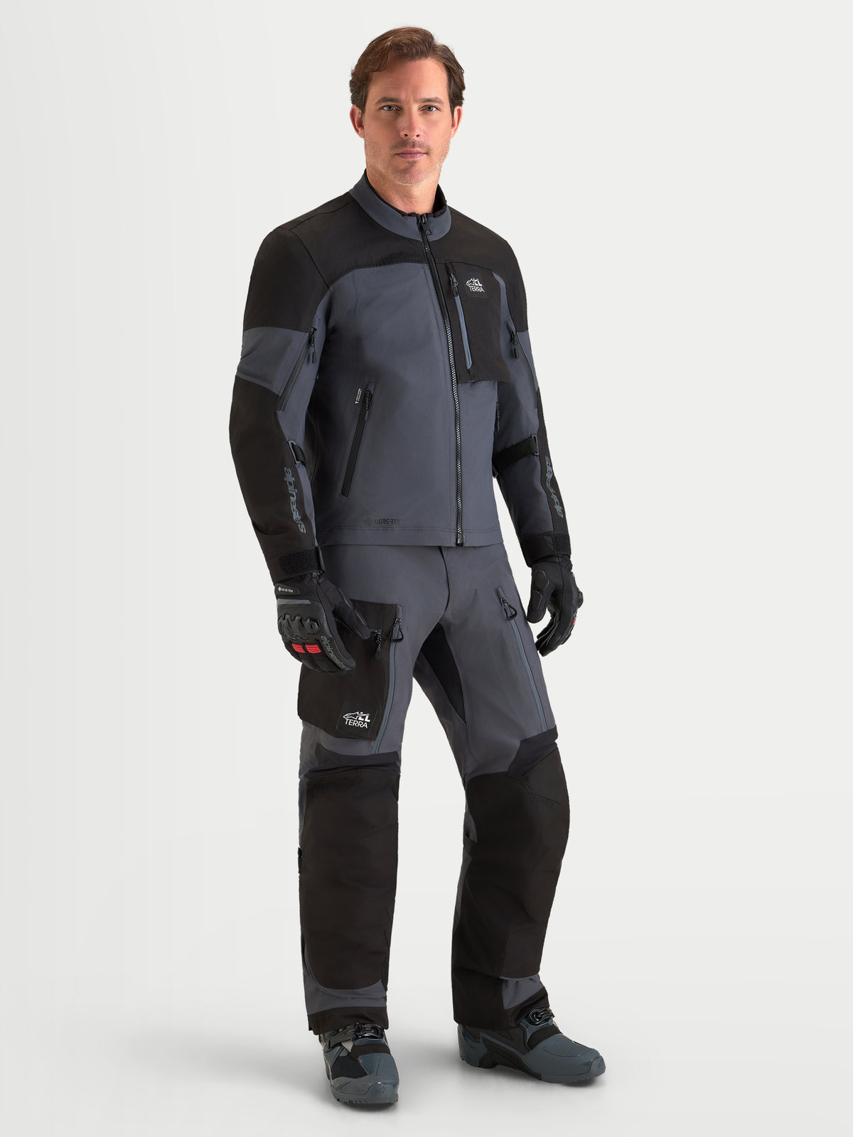Alpinestars Arenis Gore-Tex Gear Set, tenue complète de moto adventure pour homme en noir et gris foncé, vue de face sur un modèle portant un équipement de protection étanche assorti