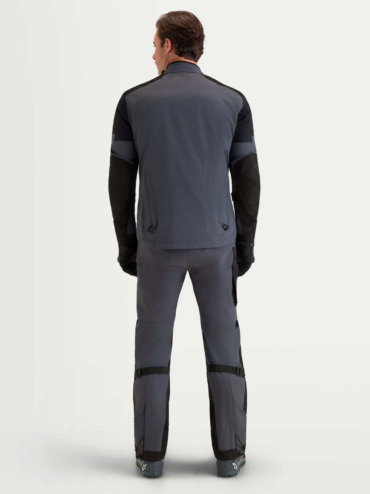 Alpinestars Arenis Gore-Tex Tenue complète, veste et pantalon de moto adventure pour homme gris et noir, vue de dos sur un modèle portant un équipement d'équitation imperméable