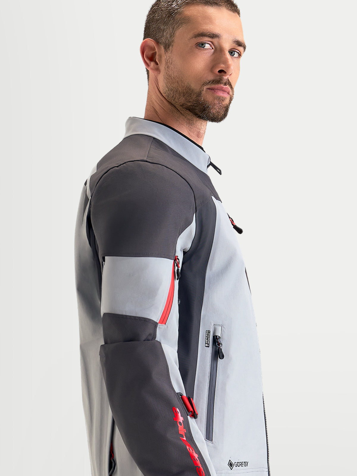 Alpinestars Veste Arenis Gore-Tex, veste de moto adventure pour homme en gris moyen, gris foncé et noir, vue de profil montrant la construction textile imperméable et le col ergonomique