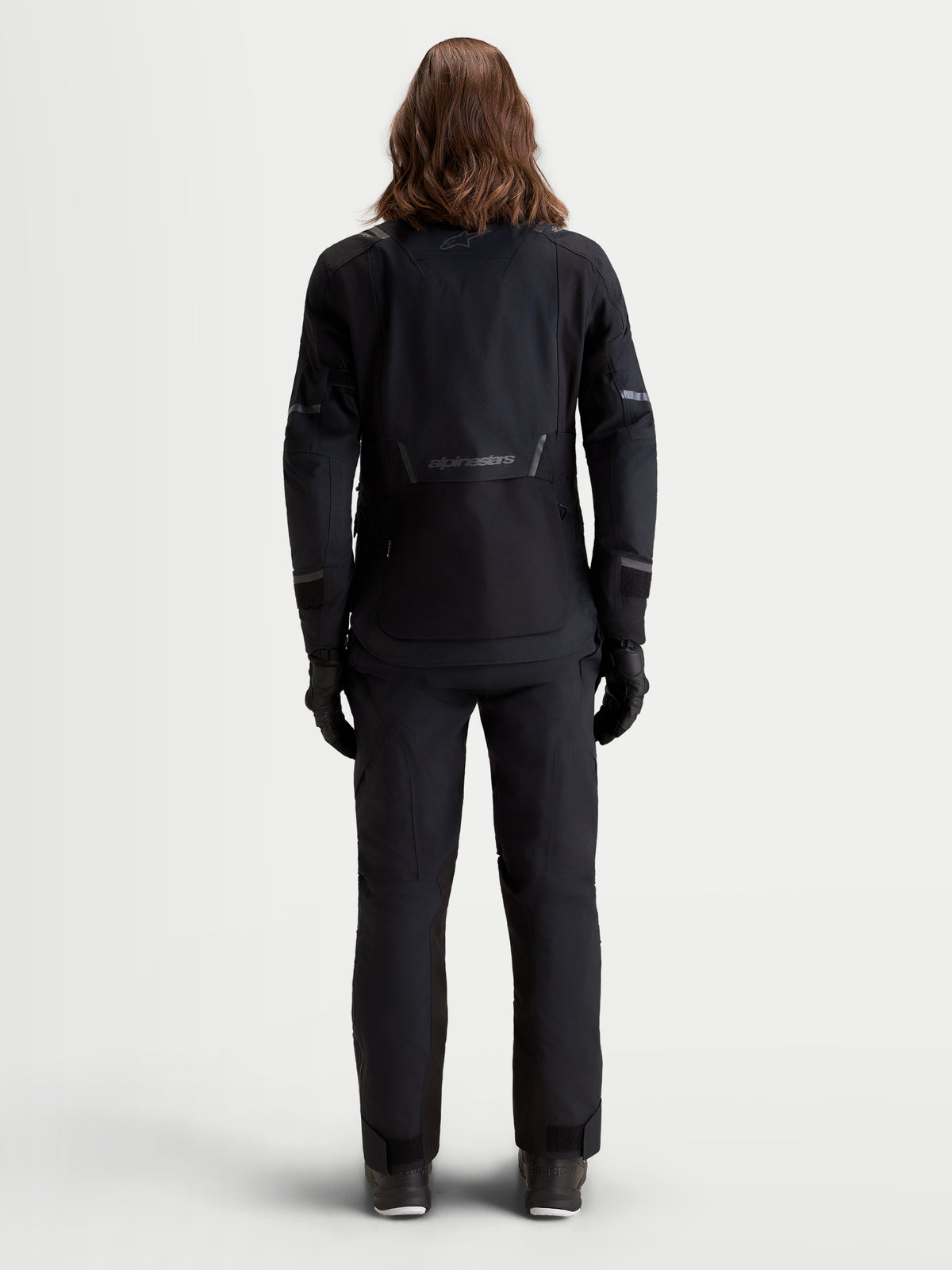 Alpinestars Stella ST-7 V2 2L Gore-Tex, veste de moto adventure pour femme noire, vue de dos sur un modèle montrant la construction textile imperméable et les détails réfléchissants