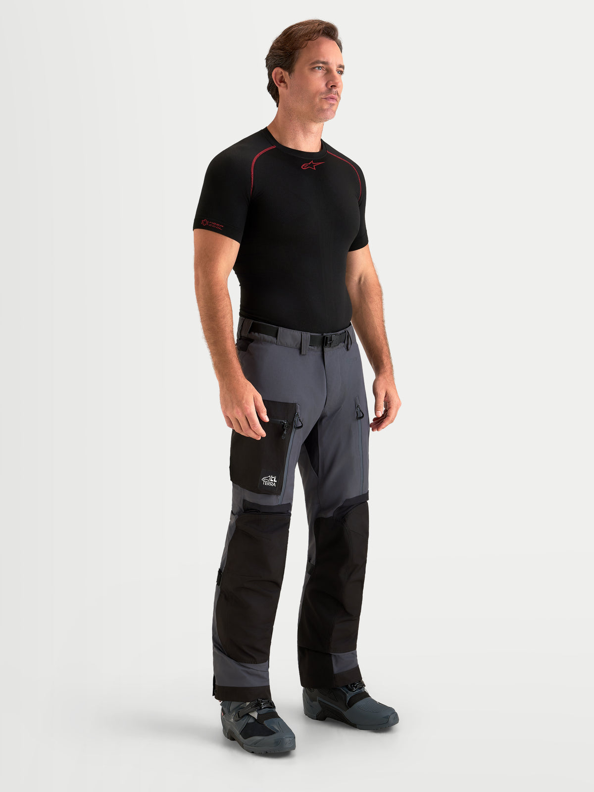 Alpinestars Arenis Gore-Tex Pantalons, pantalon de moto adventure pour homme en gris foncé et noir, vue de face sur un modèle portant un équipement assorti et une construction textile imperméable