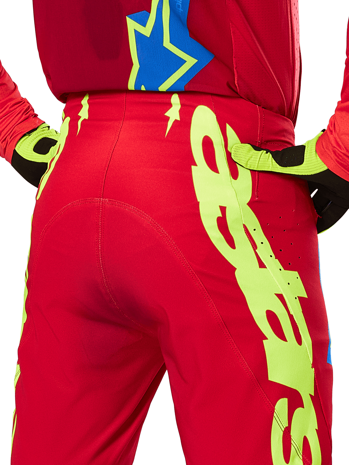 Alpinestars 2025 Supertech Maker Pants, pantalon de motocross, rouge vif et jaune fluo, vue arrière présentant de larges graphismes jaunes sur les jambes et des gants assortis jaune fluo et noir, équipement de course professionnel tout-terrain