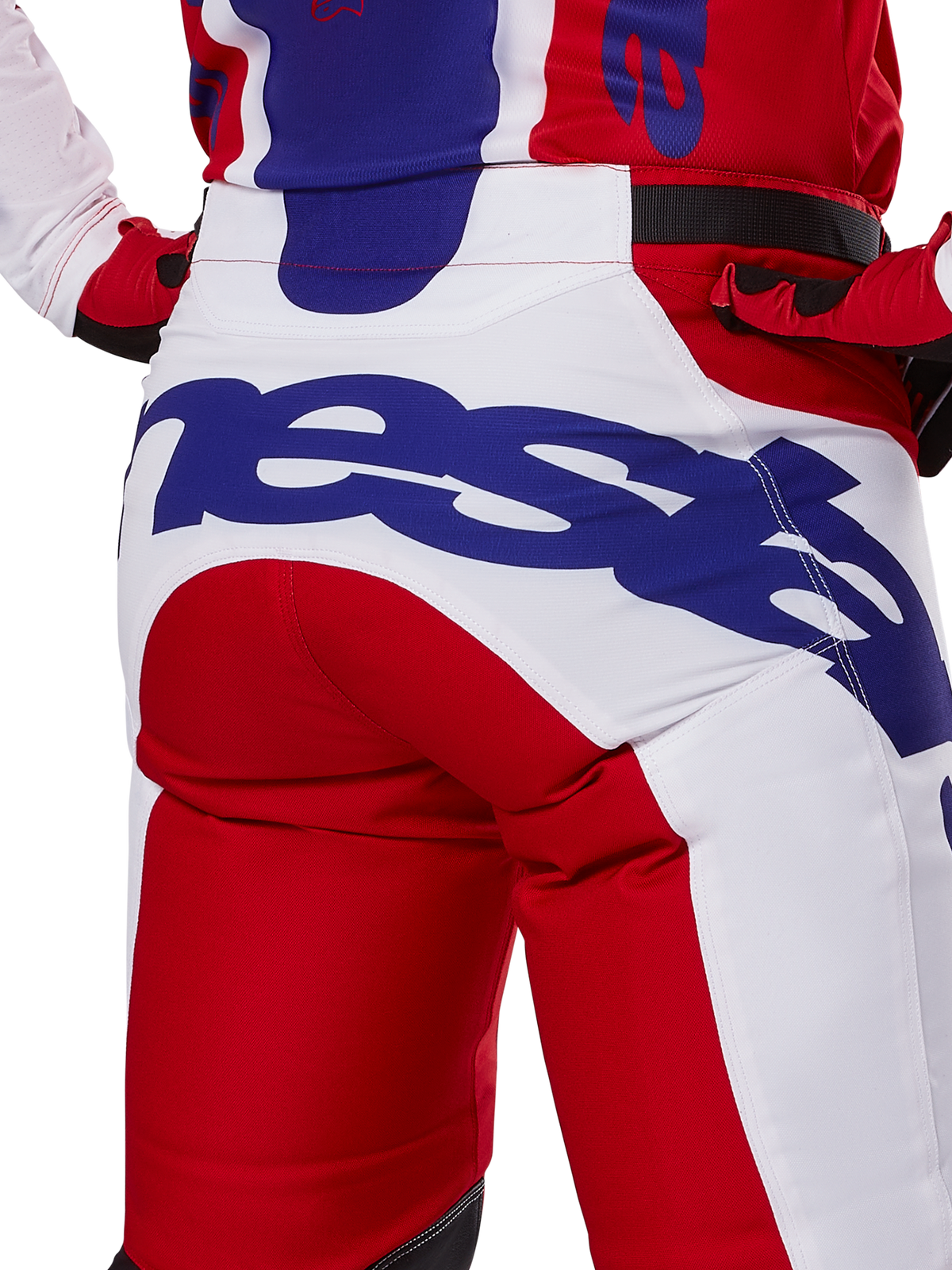 Alpinestars 2025 Racer Veil Pants, pantalon de motocross, rouge vif et blanc avec logo bleu, vue arrière détaillée de l'assise présentant un grand logo Alpinestars, porté dans le cadre d'une tenue de course tout-terrain coordonnée