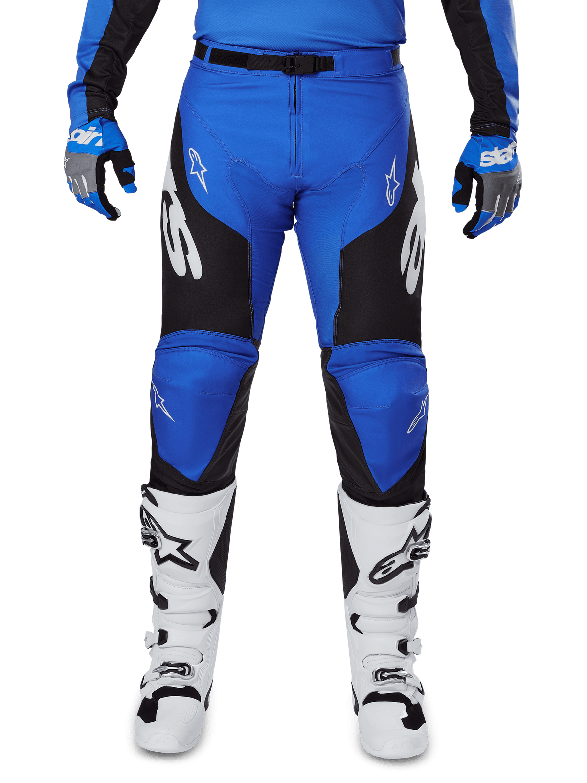 Pantalon Alpinestars Racer Veil 2025, pantalon de motocross, bleu et noir, avec logos Alpinestars blancs sur les jambes, empiècements latéraux noirs, porté avec des bottes de motocross blanches et des gants bleus et gris, équipement de conduite tout-terrain haute performance