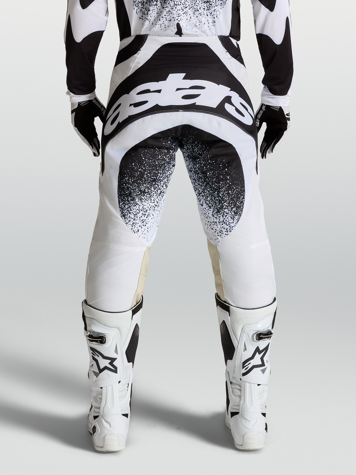 Pantalon Techstar Swan Alpinestars, pantalon de motocross professionnel, noir et blanc, vue de dos avec logo graphique et construction de genou Babel.