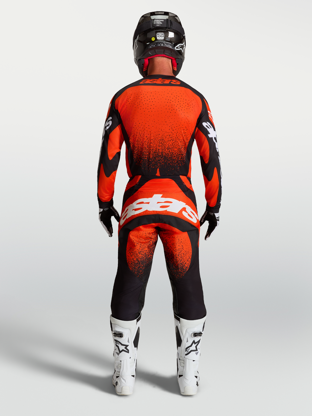 Pantalons Techstar Swan Alpinestars, équipement motocross rouge cardinal et noir, vue de dos avec bottes de course blanches.