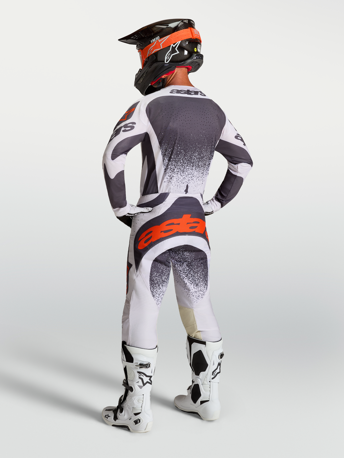 Ensemble Alpinestars Techstar Swan, maillot et pantalon de motocross pour homme, gris, blanc et rouge fluo, vue de dos.