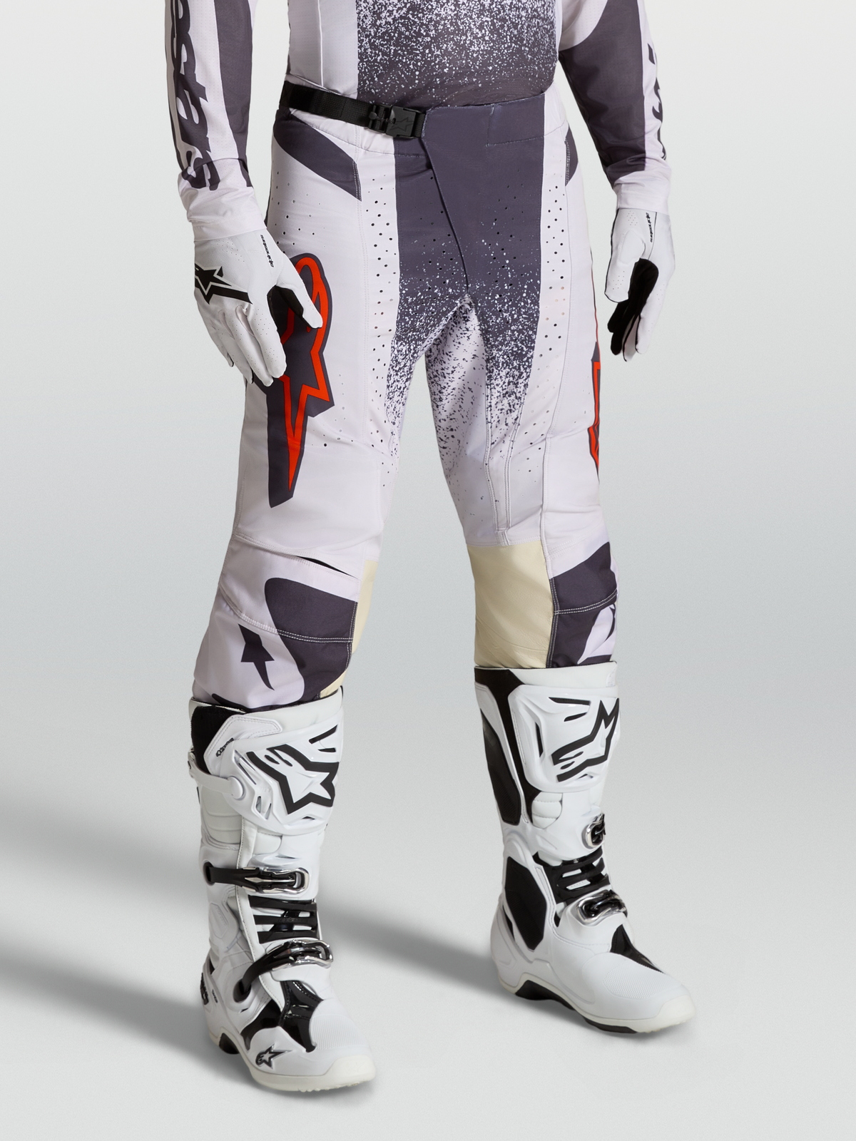 Alpinestars Pantalon Techstar Swan, pantalon de motocross pour homme, lilas clair et gris foncé avec accents rouge fluo, porté avec gants et bottes assortis