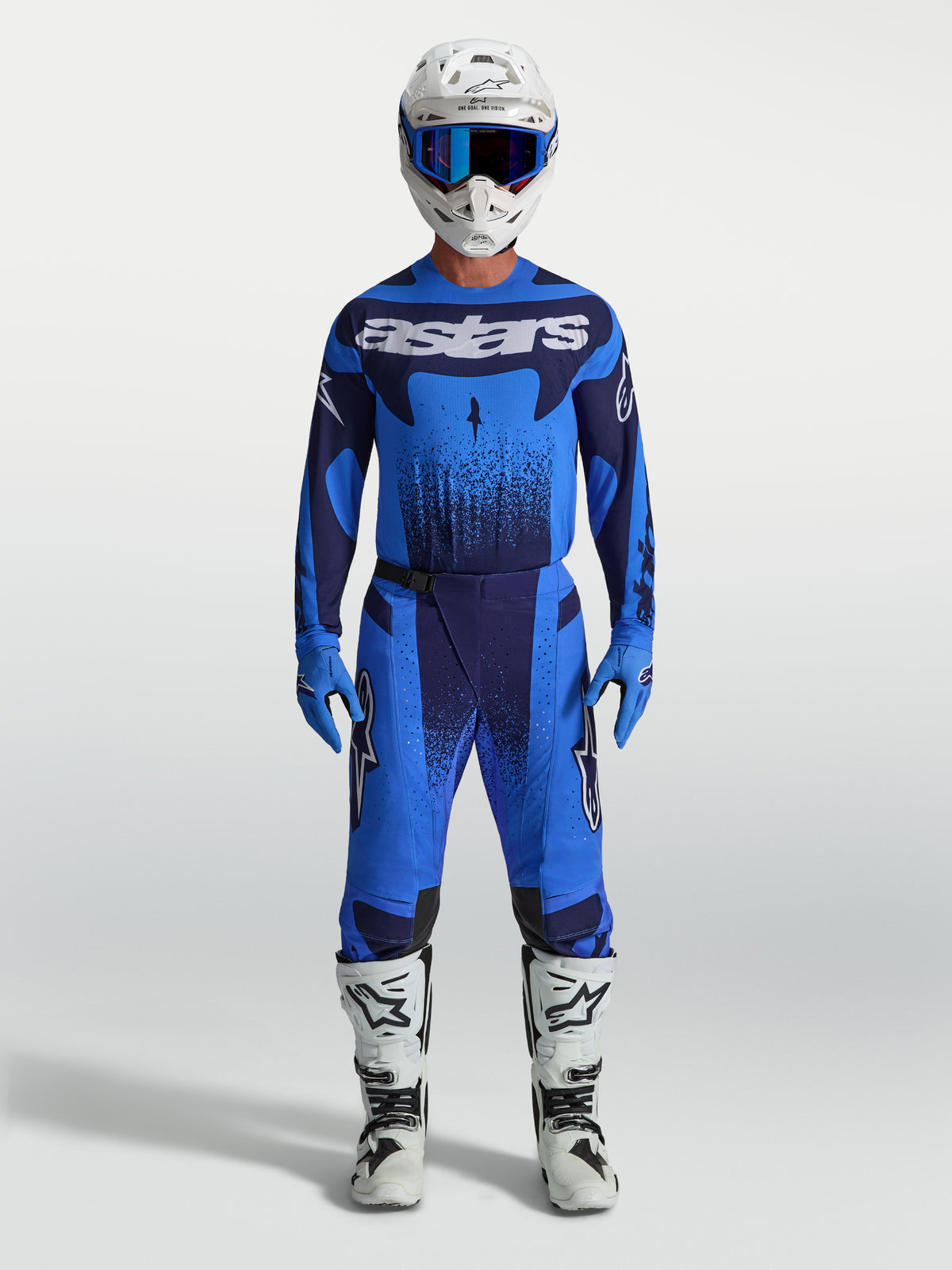 Alpinestars Techstar Swan, pantalon de motocross pour homme, bleu UCLA et bleu foncé, porté avec des bottes blanches.