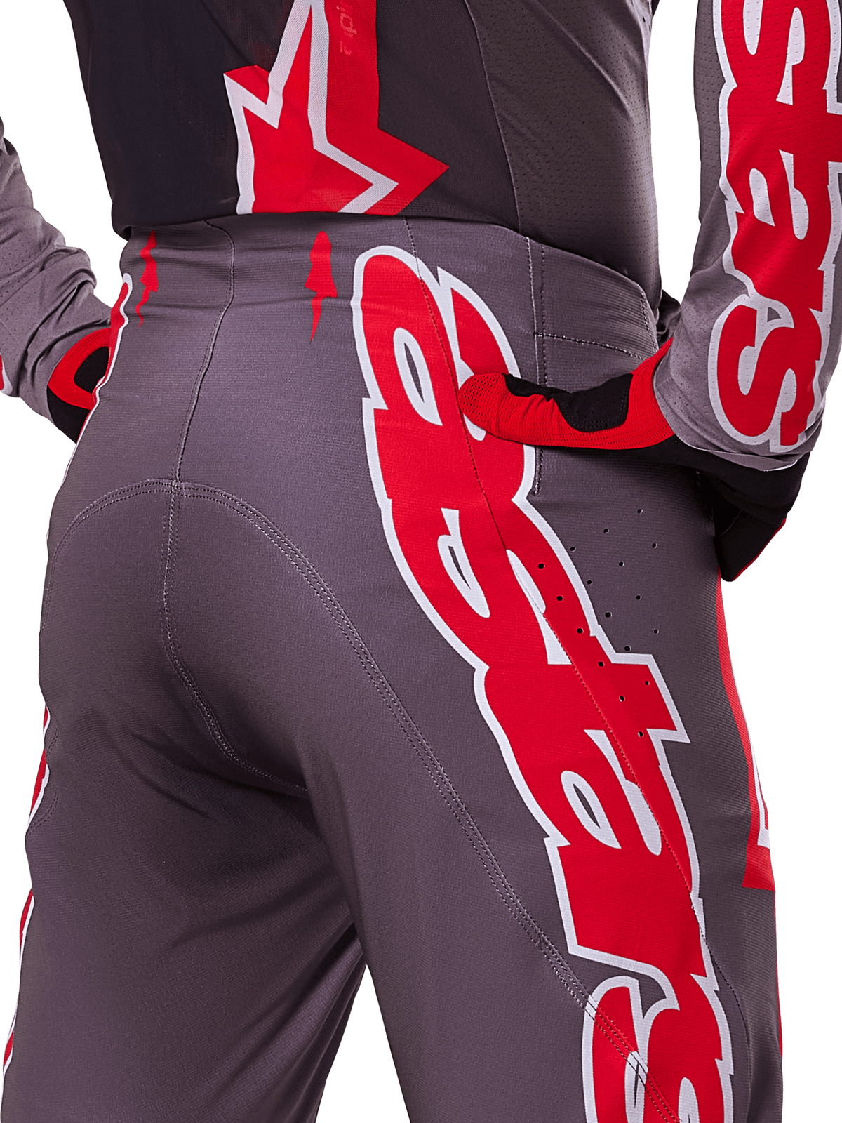 Alpinestars 2025 Supertech Lipan Pants, Motocross Pants, Smoke Bright Red and Gray, close-up of hip and rear showing bold red and white logo graphics, ventilation perforations, and athletic race fit worn with matching gear.