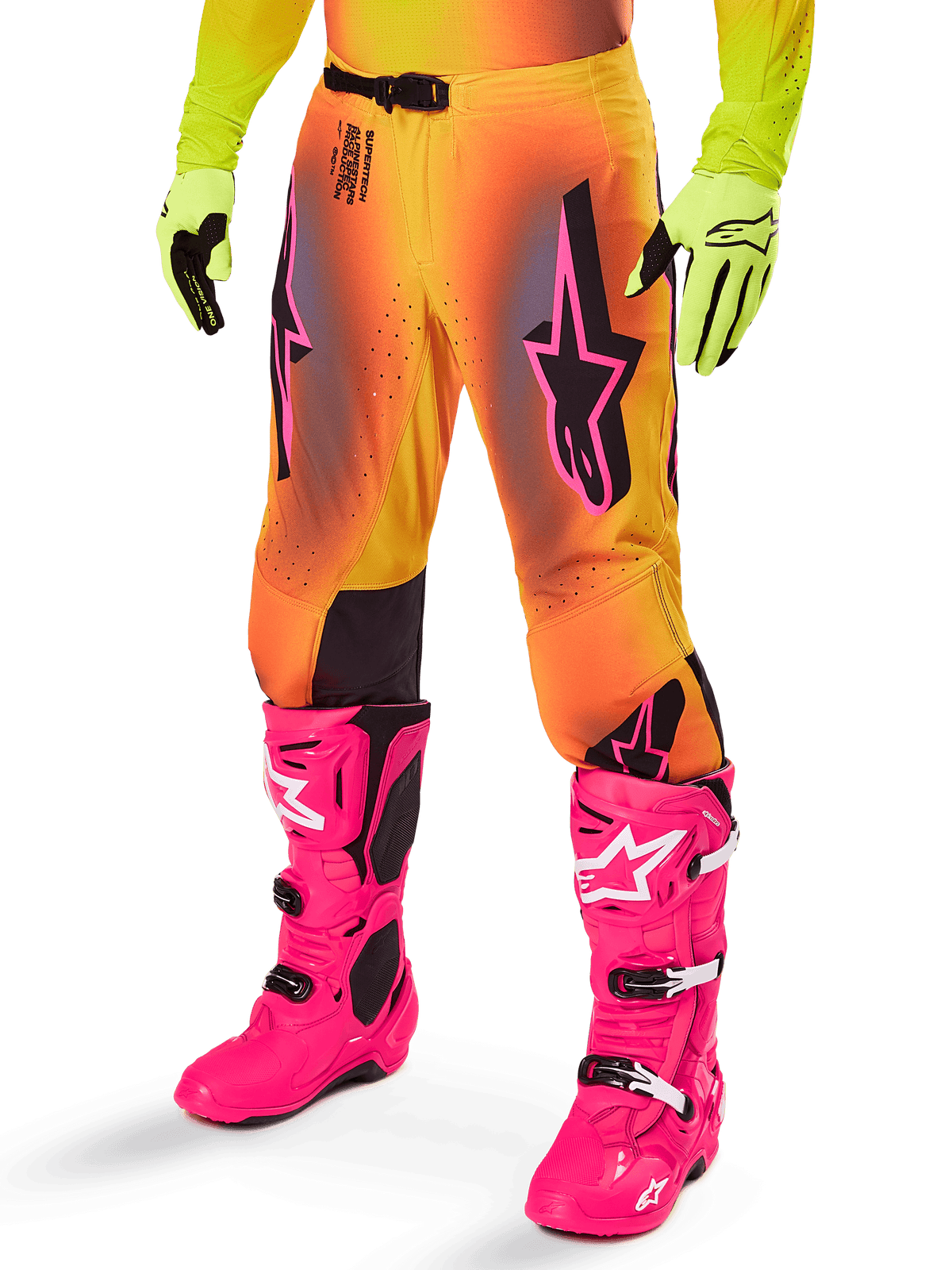 Alpinestars 2025 Supertech Lipan Gear Set, pantalon de motocross, dégradé jaune et orange avec accents rose et violet, logos Alpinestars noirs sur les cuisses, porté avec des gants jaunes et des bottes de motocross rose vif.
