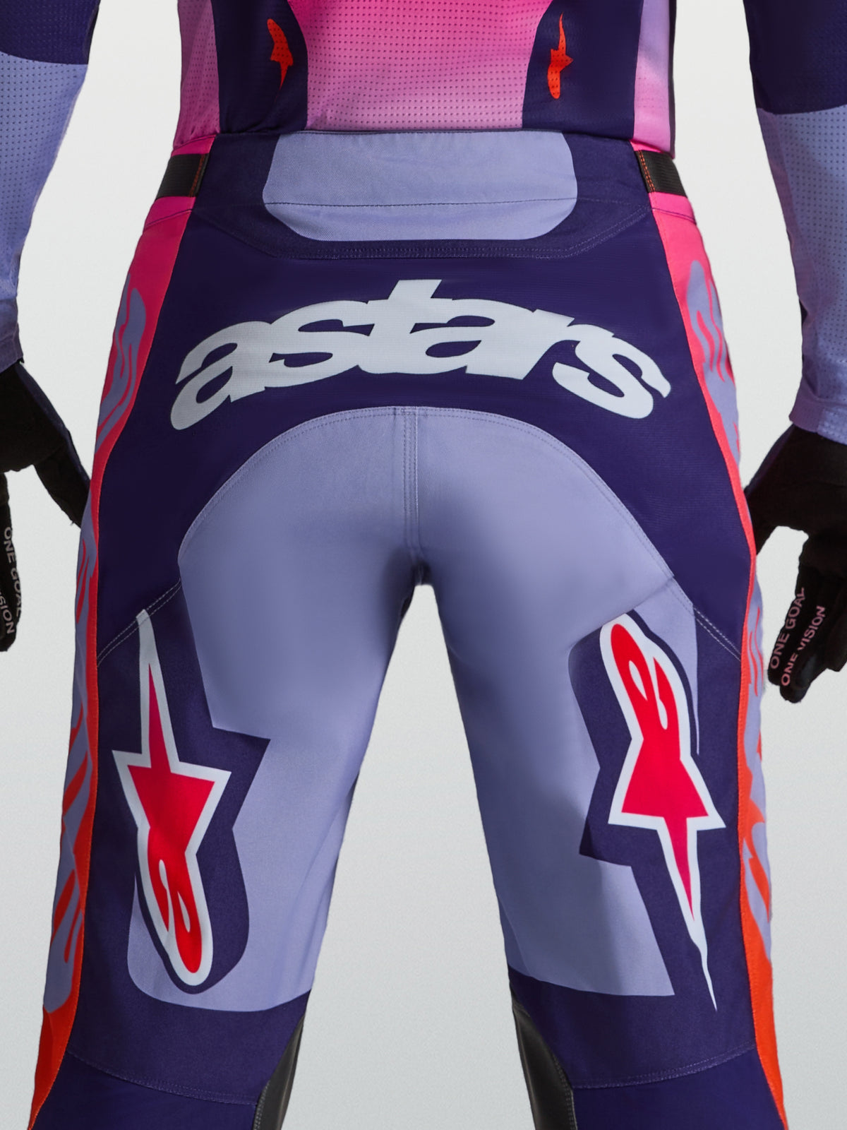 Pantalons Racer Air Hunt Alpinestars, pantalons de motocross violets et roses, vue arrière avec logo astars et tissu ventilé.