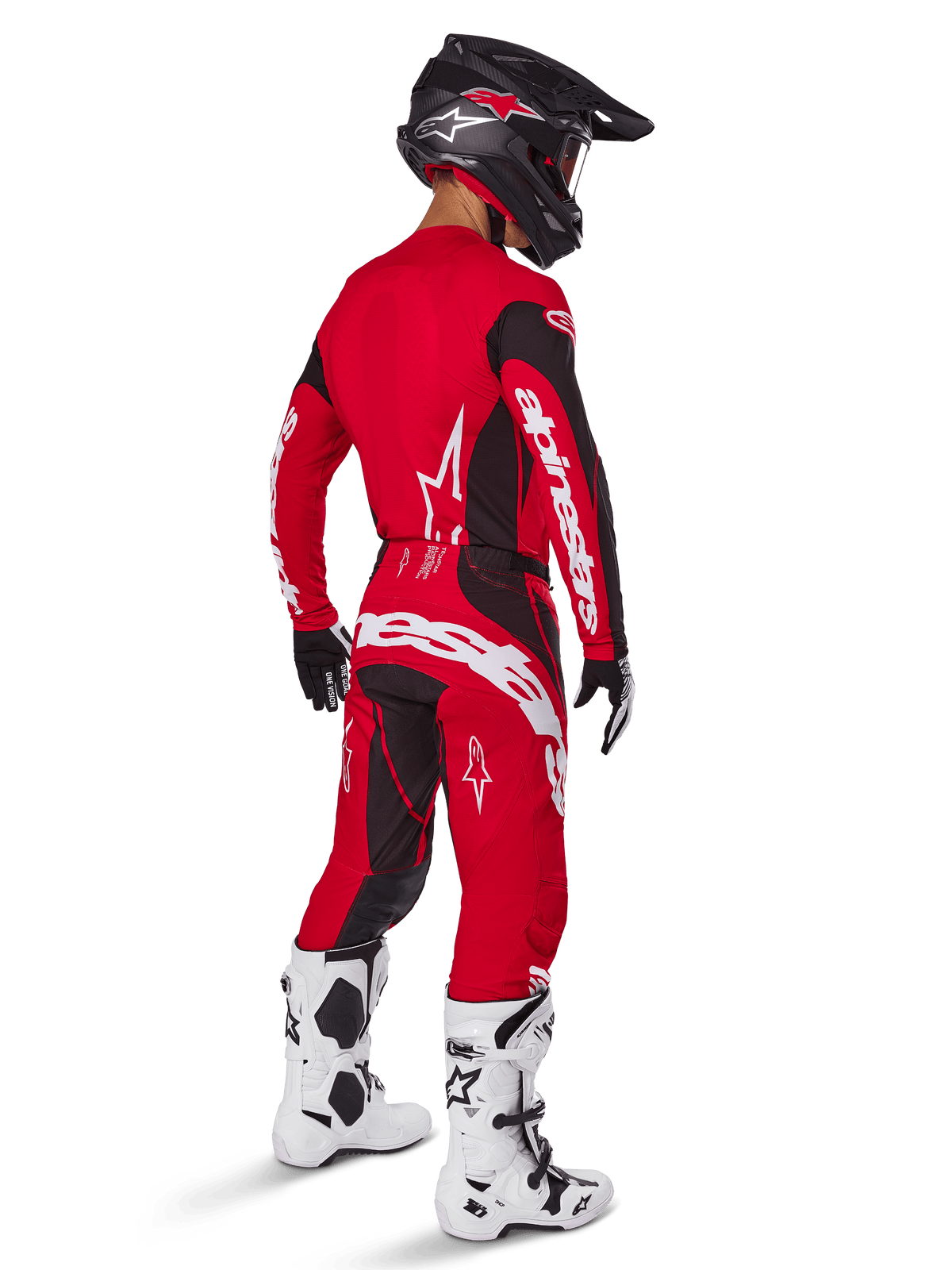 Pantalon Alpinestars Techstar Dreem 2025, pantalon de motocross, rouge vif et noir, porté par un pilote vu de dos dans une tenue de course complète avec maillot rouge assorti, casque noir et bottes blanches, avec logo Alpinestars blanc et empiècements extensibles noirs.