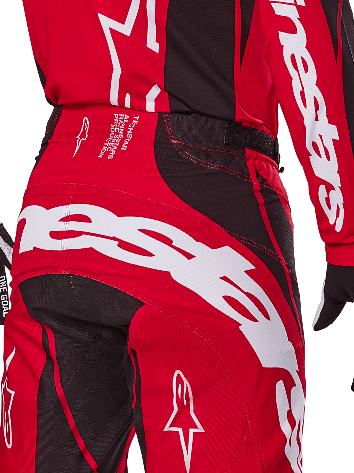 Alpinestars Techstar Dreem Pants 2025, pantalon de motocross, rouge vif et noir, gros plan sur l'arrière de la taille et l'assise avec marquage Alpinestars blanc, empiècements extensibles noirs et texte technique sur la ceinture, conçu pour la performance tout-terrain