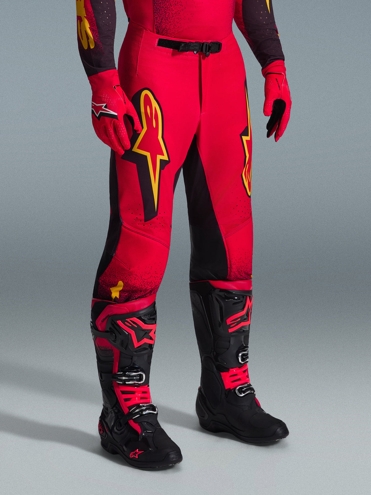 Alpinestars 2026 Supertech Scenz Pants, Motocross Pants, Red Black and Yellow, featuring yellow Alpinestars logos and black panels, worn with matching red jersey, red gloves, and black motocross boots.