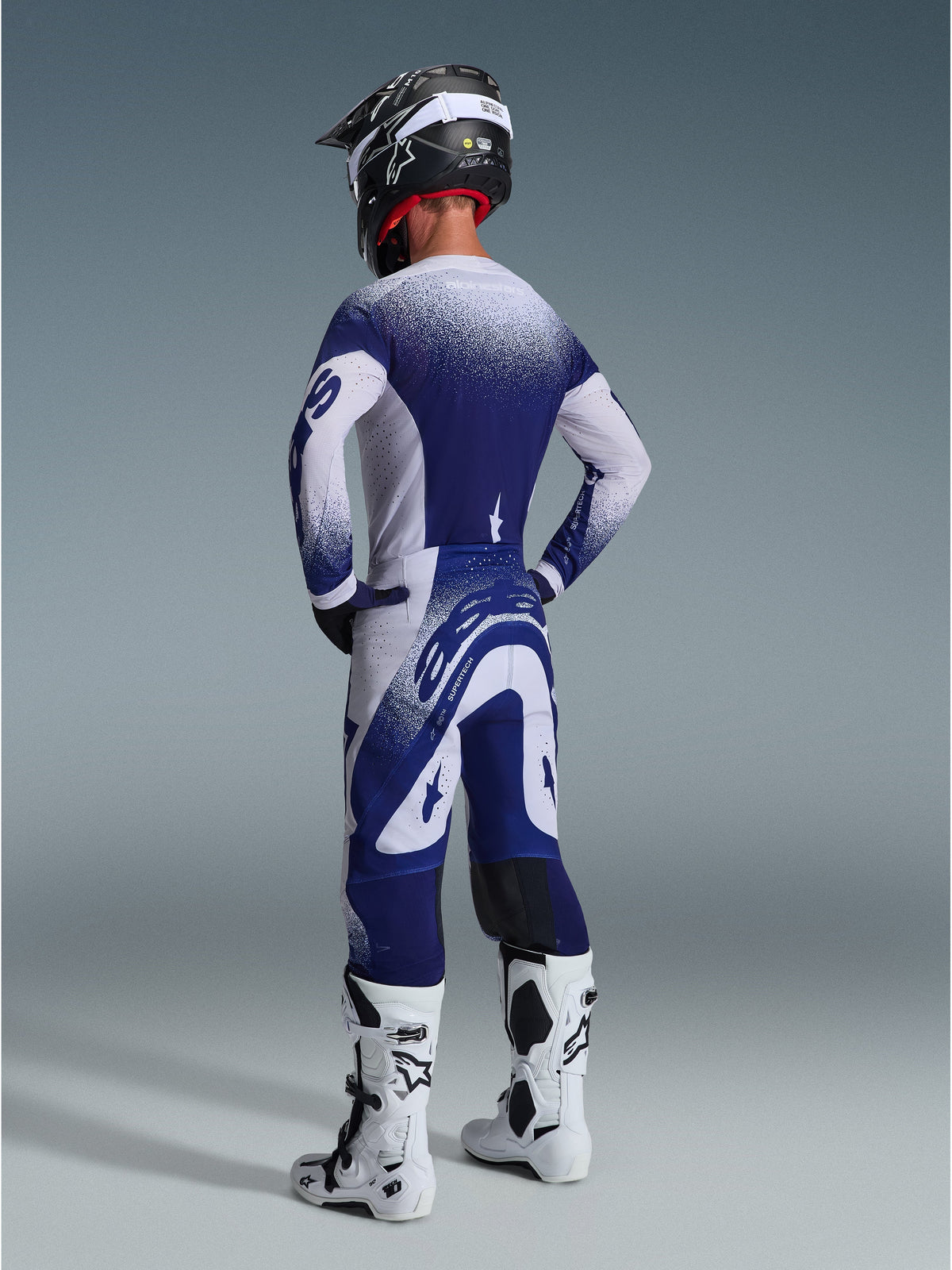 Alpinestars 2026 Supertech Scenz Pants, Motocross Pants, Light Gray and Dark Blue, rear view worn with matching jersey and white boots, featuring gradient dot graphics and performance athletic fit for off-road racing.