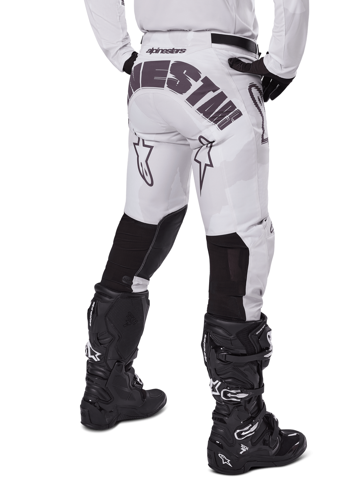 Alpinestars 2025 Racer Hollow Pants, pantalon de motocross, brun camouflage clair, vue arrière du pilote montrant un logo imposant sur l'assise et des empiècements extensibles noirs sur le bas des jambes, associé à des bottes Tech 7 noires