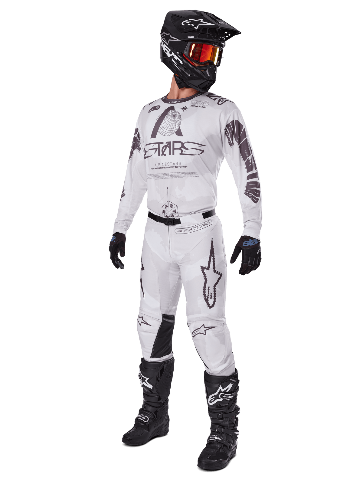 Alpinestars 2025 Racer Hollow Pants, pantalon de motocross, Brun Camo Clair, présenté dans un kit de course complet avec maillot blanc, casque noir et bottes noires, doté de panneaux de genoux noirs renforcés et d'un motif camouflage subtil.