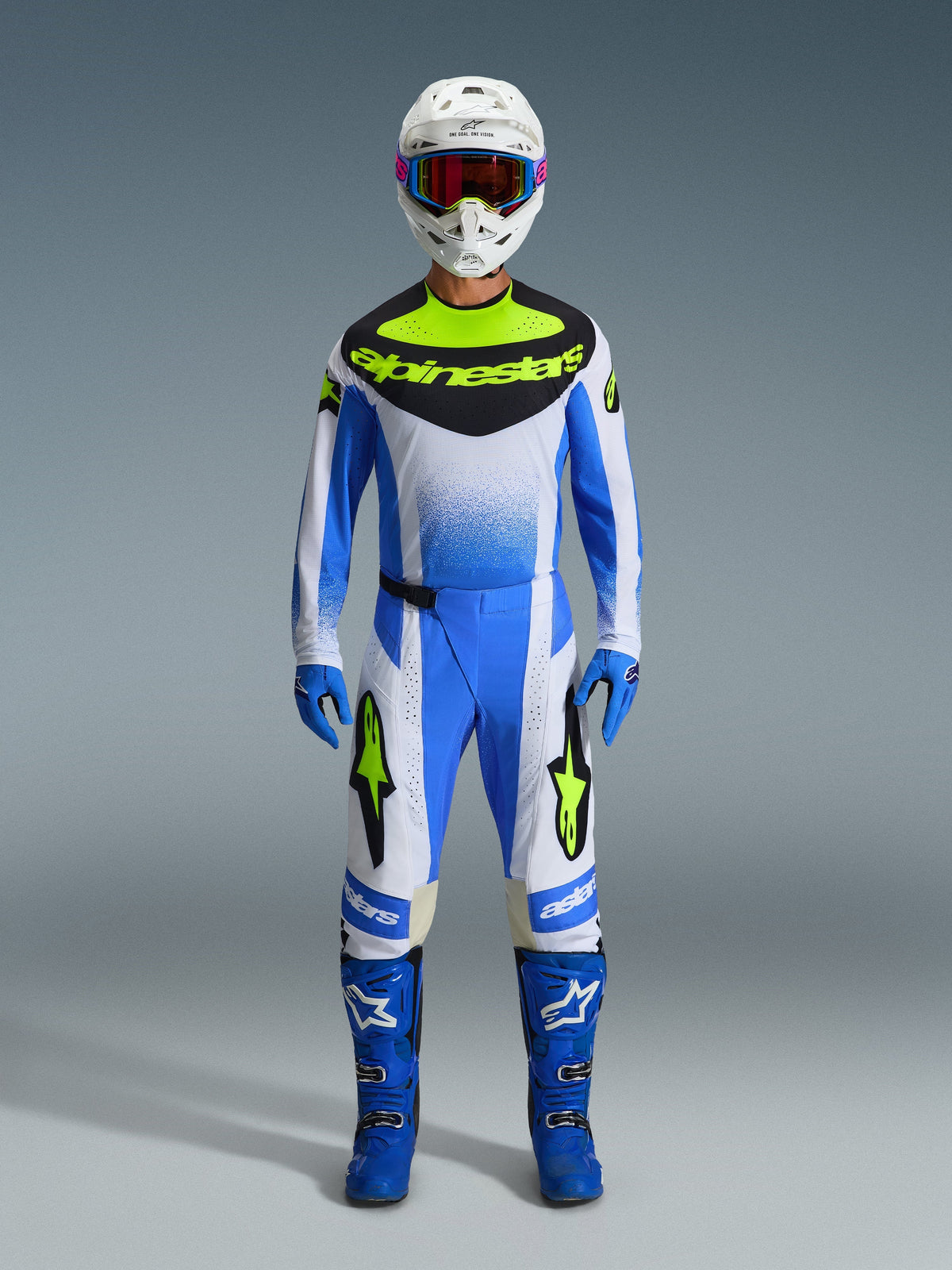 Pantalon Alpinestars Techstar Knif 2026, pantalon de motocross, bleu UCLA, noir et jaune fluo, faisant partie d'une tenue de course complète avec maillot assorti, bottes bleues, gants bleus et casque blanc, coupe de course athlétique avec marquage Alpinestars audacieux.