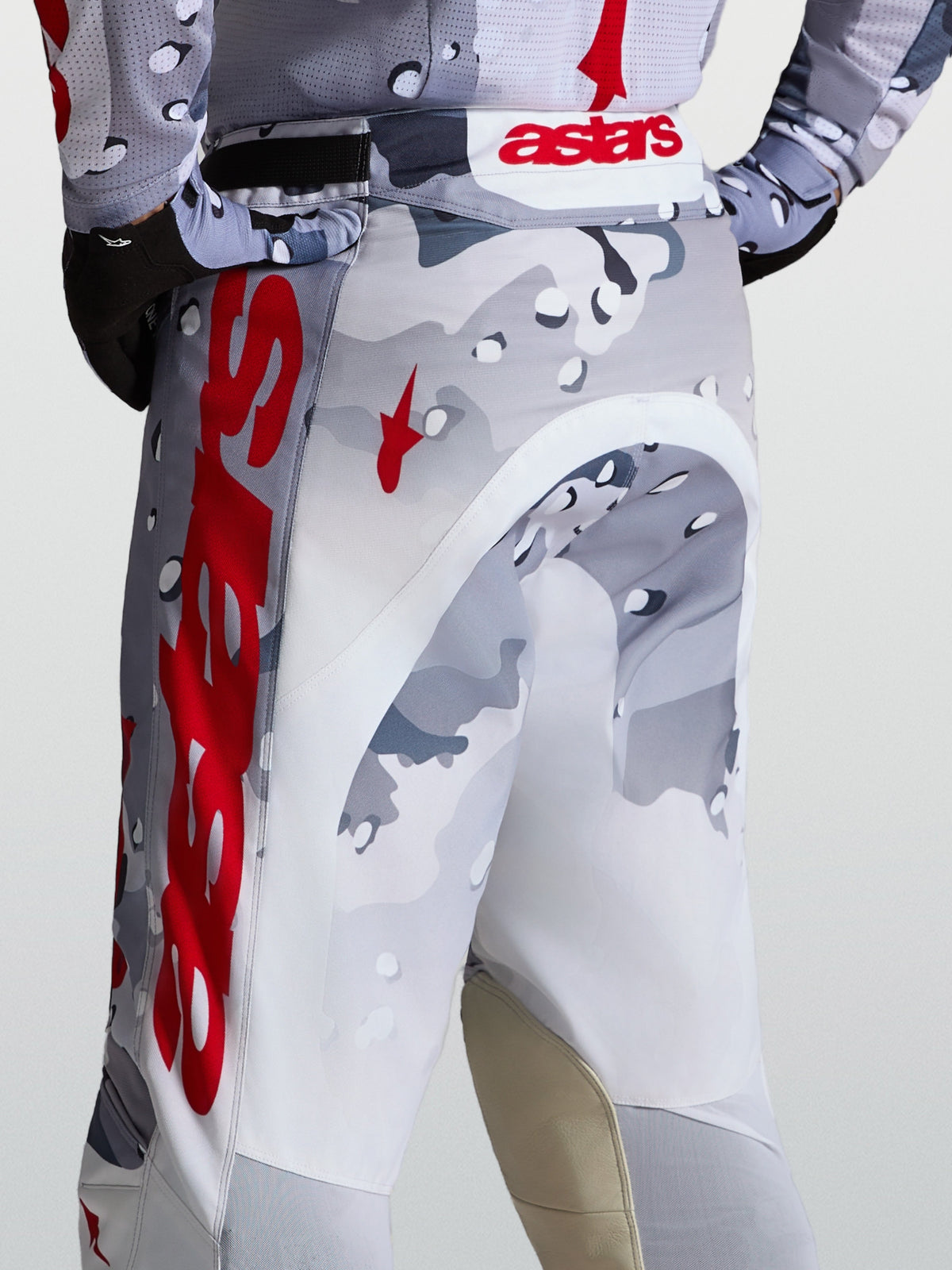 Alpinestars Pantalon Racer Air Lone, pantalon de motocross pour homme, gris camouflage et rouge, construction en polyfibre perforée ultra-aérée, vue de dos sur un pilote tout-terrain