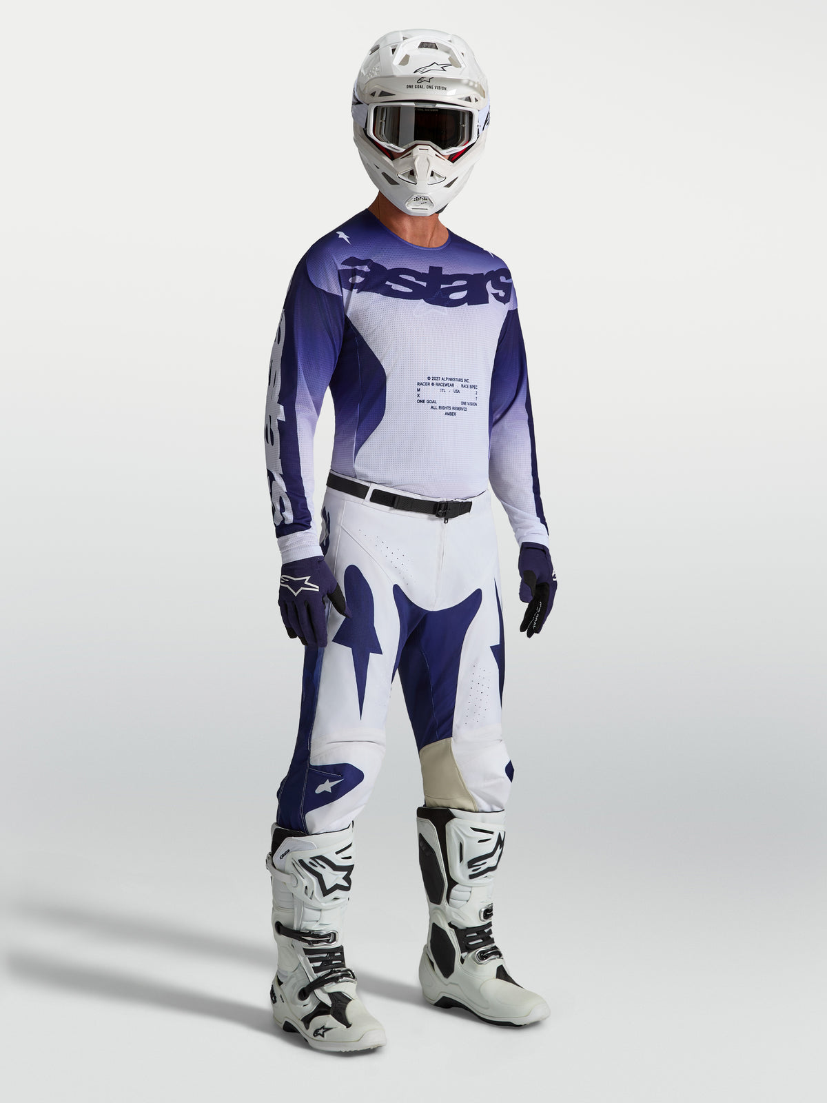 Pantalon Alpinestars Racer Air Amber, pantalon de motocross pour homme, bleu et blanc, porté par un mannequin avec maillot et bottes assortis, équipement tout-terrain léger et ventilé