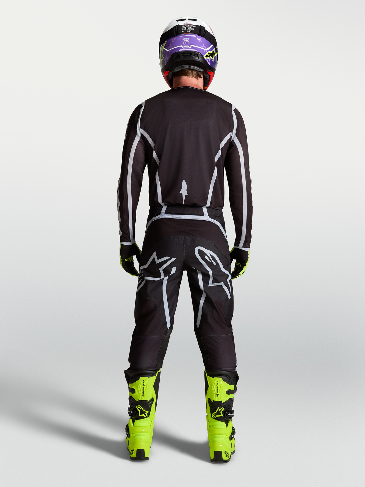 Pantalon Alpinestars Fluid Apex V2, pantalon de motocross pour homme, noir et argenté, vue arrière sur pilote avec coupe sport ergonomique