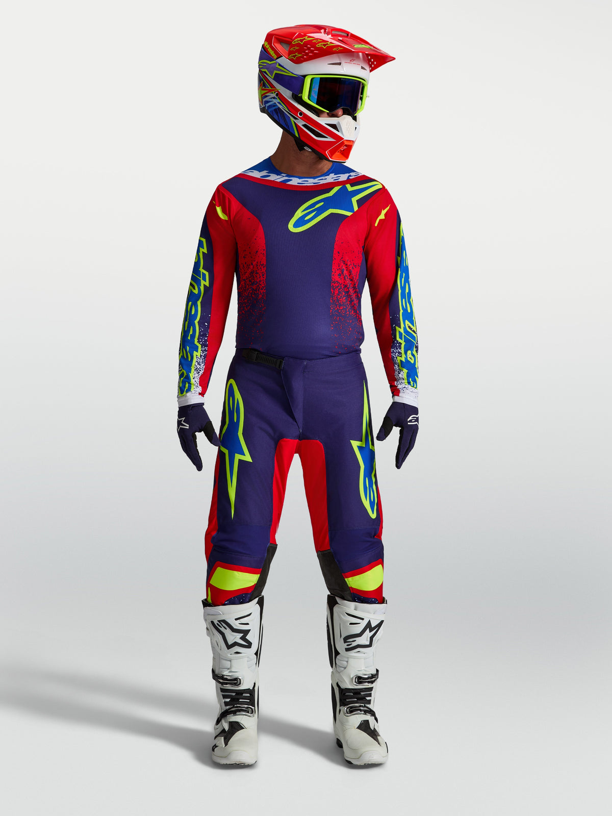 Alpinestars Pantalons Fluid Drag et Fluid Drag Gear Set 2027, tenue motocross homme bleu marine et rouge, bottes blanches.