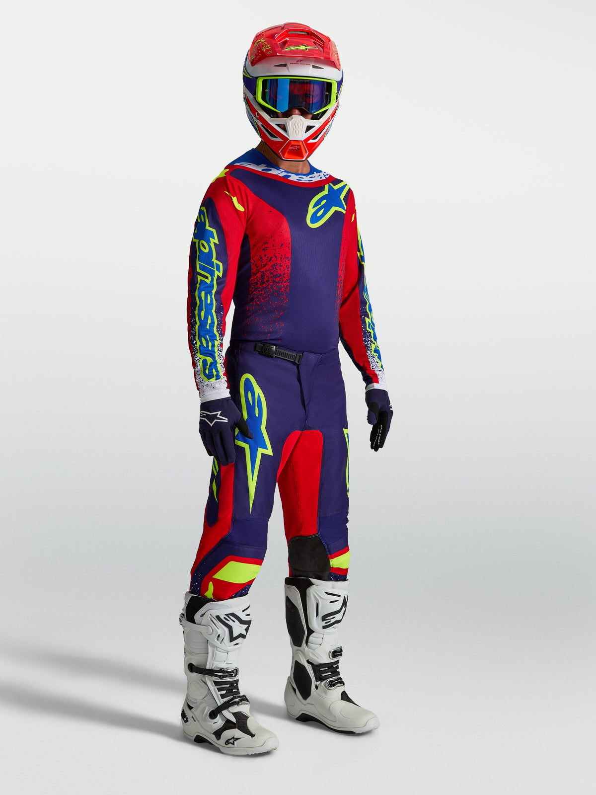 Alpinestars Fluid Drag, ensemble de motocross pour homme, bleu marine et rouge, bottes blanches, tenue de performance off-road.