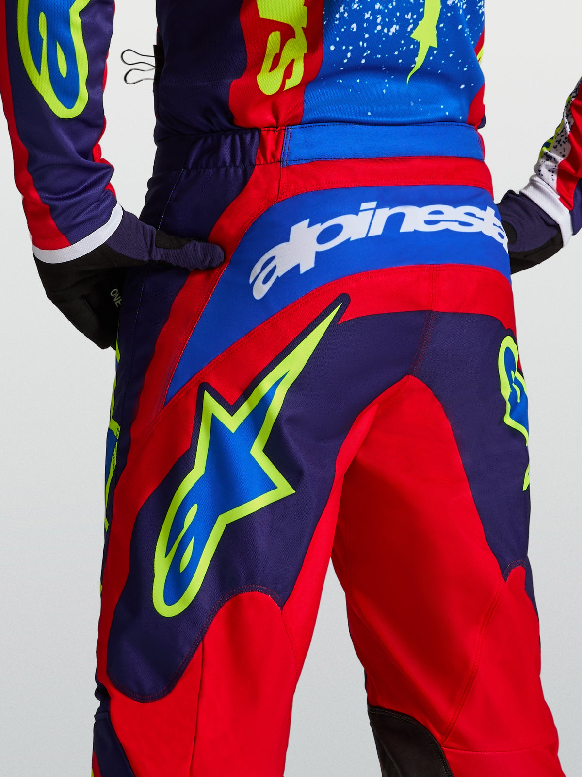 Pantalons Alpinestars Fluid Drag, pantalons de motocross, bleu marine et rouge feu, graphismes d'étoiles, coupe sport.