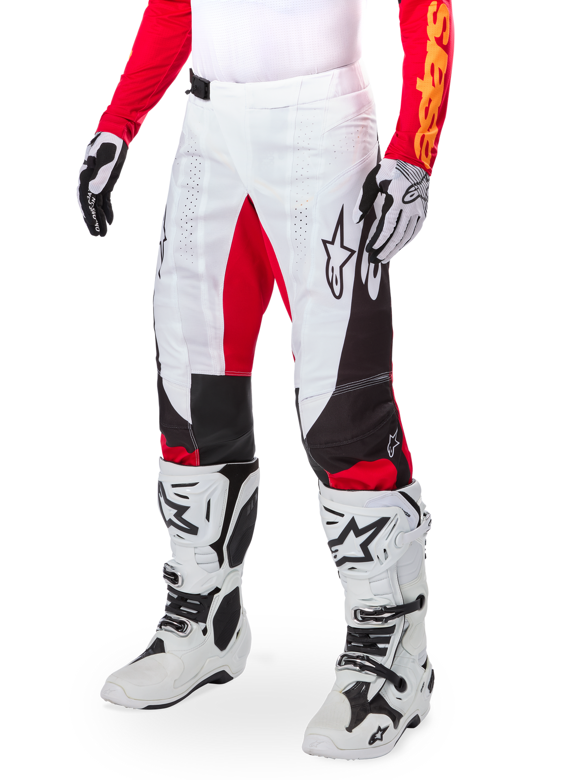 Alpinestars Techstar Deep Édition Limitée, pantalon de motocross, blanc, noir et rouge vif, porté avec des bottes et des gants blancs et noirs, doté de panneaux avant blancs avec des accents rouges et de détails latéraux noirs, conçu pour la course tout-terrain haute performance