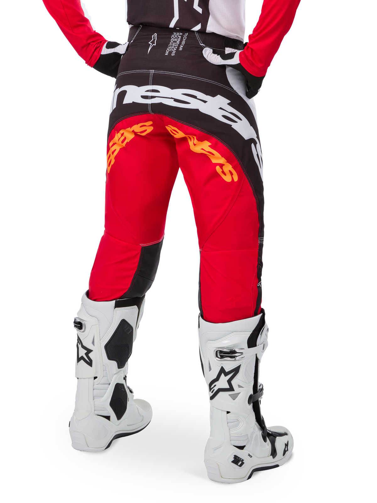 Alpinestars Techstar Deep Édition Limitée, pantalon de motocross, noir, blanc et rouge vif, vue arrière avec logo Alpinestars blanc imposant sur l'assise et marquage orange, porté avec des bottes techniques blanches pour la compétition tout-terrain professionnelle