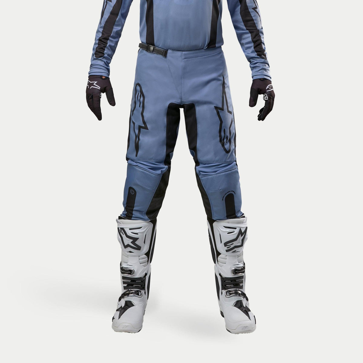 Alpinestars 2024 Fluid Lurv Pants, Motocross Pants, Light Blue and Black, worn with white and black racing boots and matching gloves, featuring bold black star logos on the thighs, ergonomic design for off-road performance