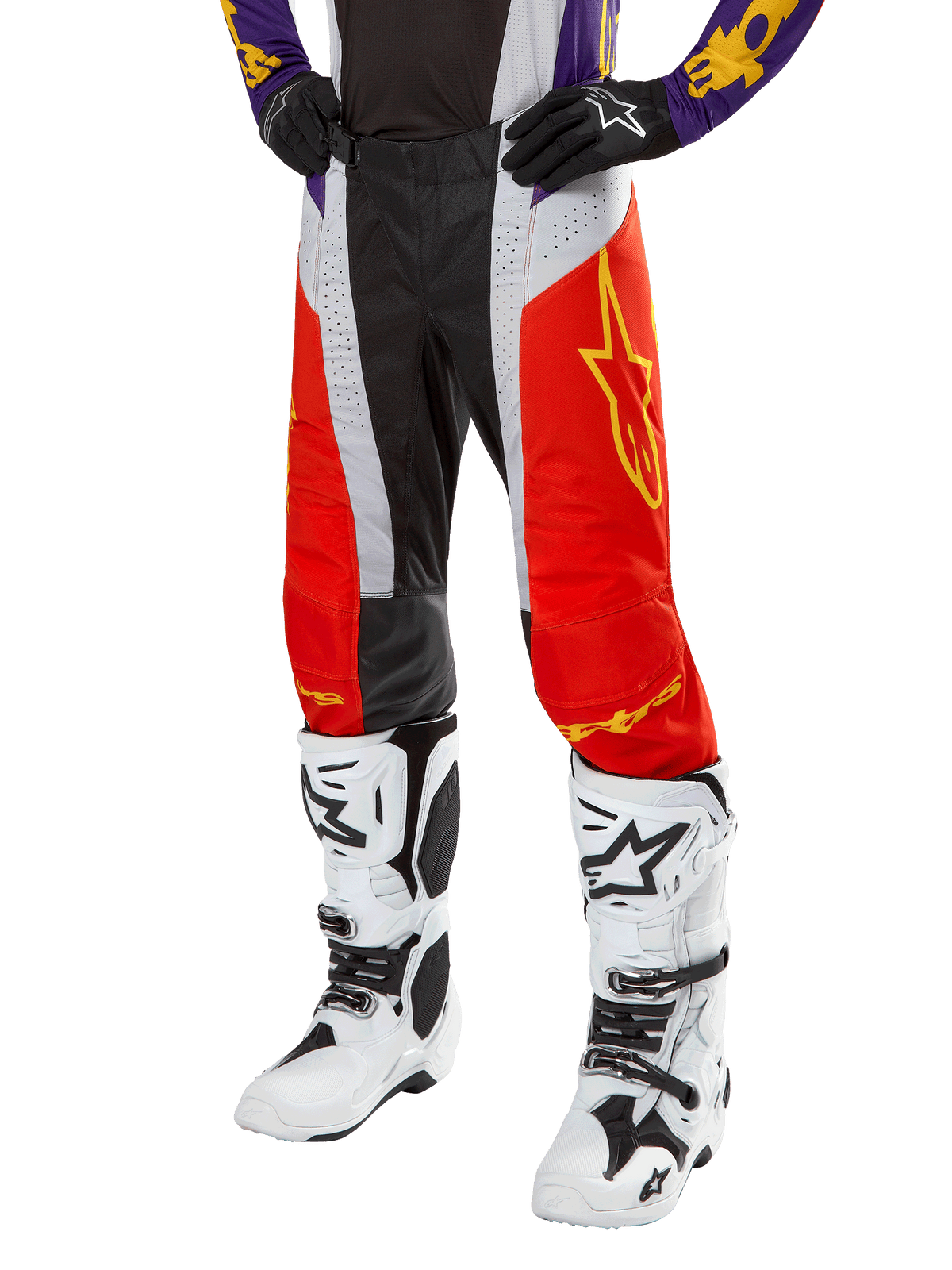 Pantalon Alpinestars Techstar Ocuri 2024, pantalon de motocross, orange vif, noir et blanc avec graphisme d'étoile jaune, porté avec un maillot violet et des bottes blanches, équipement de performance durable pour la compétition tout-terrain