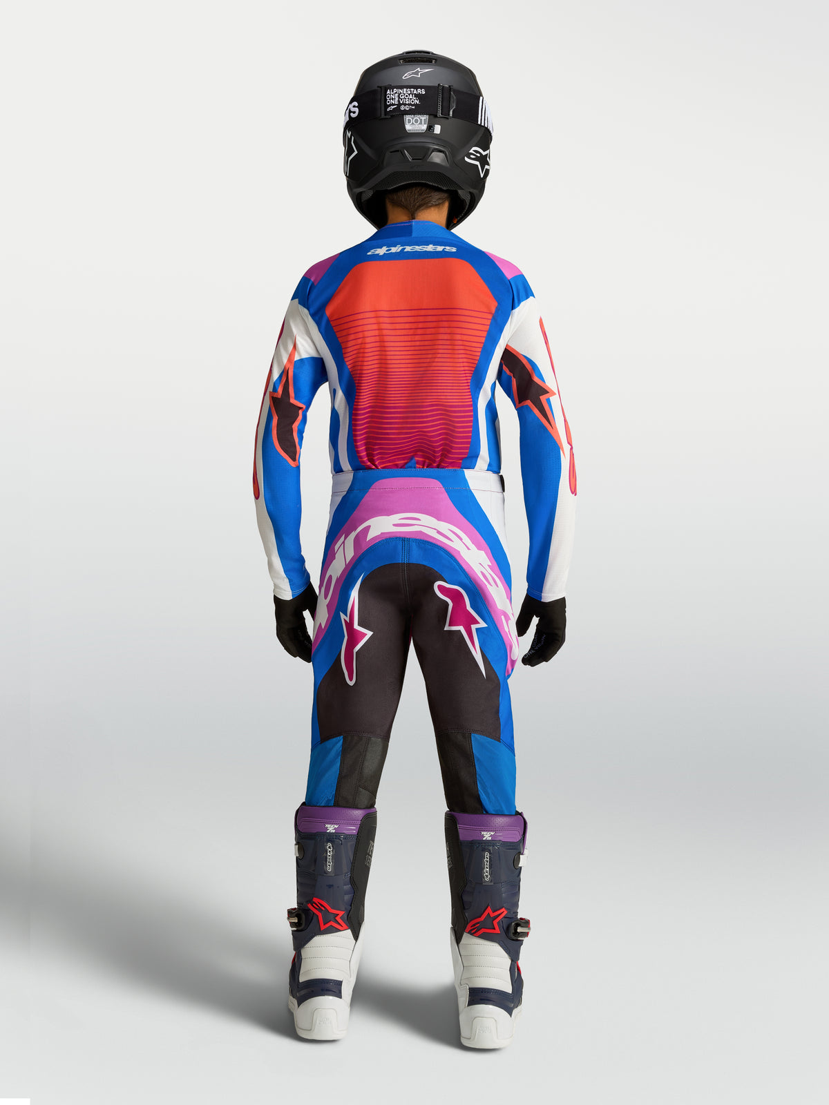 Pantalon Supertech Maven Junior Alpinestars, tenue MX bleue et corail vif, coupe athlétique, vue de dos sur jeune pilote.