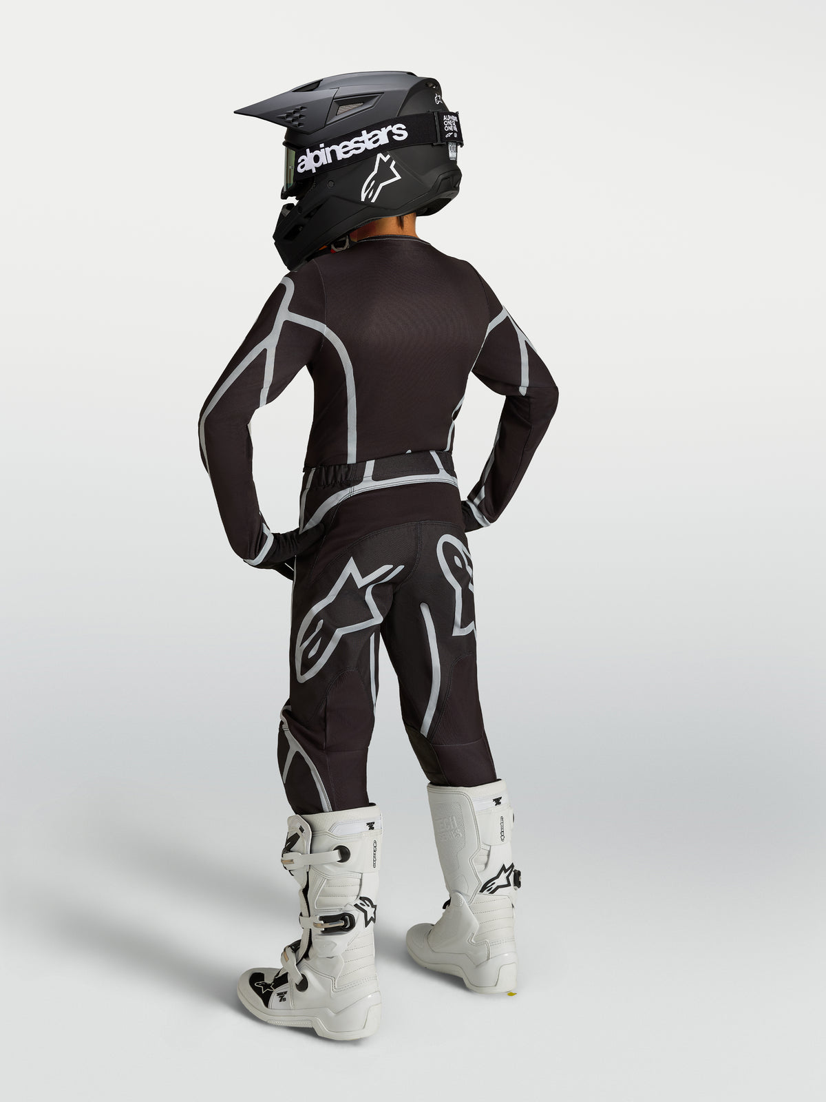 Alpinestars Pantalon Fluid Apex V2 Junior, pantalon de motocross tout-terrain pour enfant, noir et argenté, vue de dos dans un kit de course complet.