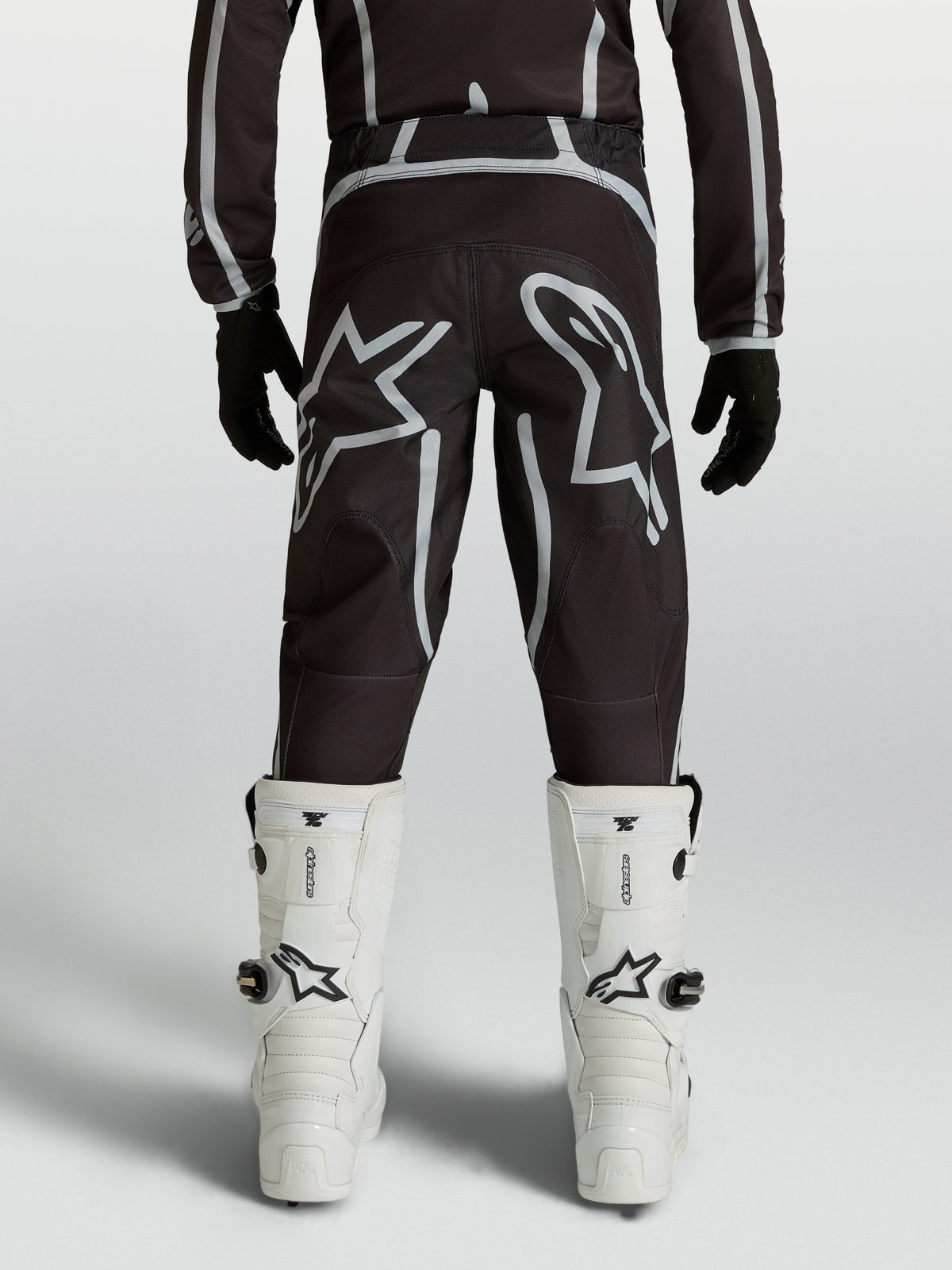 Pantalon Alpinestars Fluid Apex V2 Junior, équipement de motocross noir et argenté, coupe ergonomique et logos Astars.
