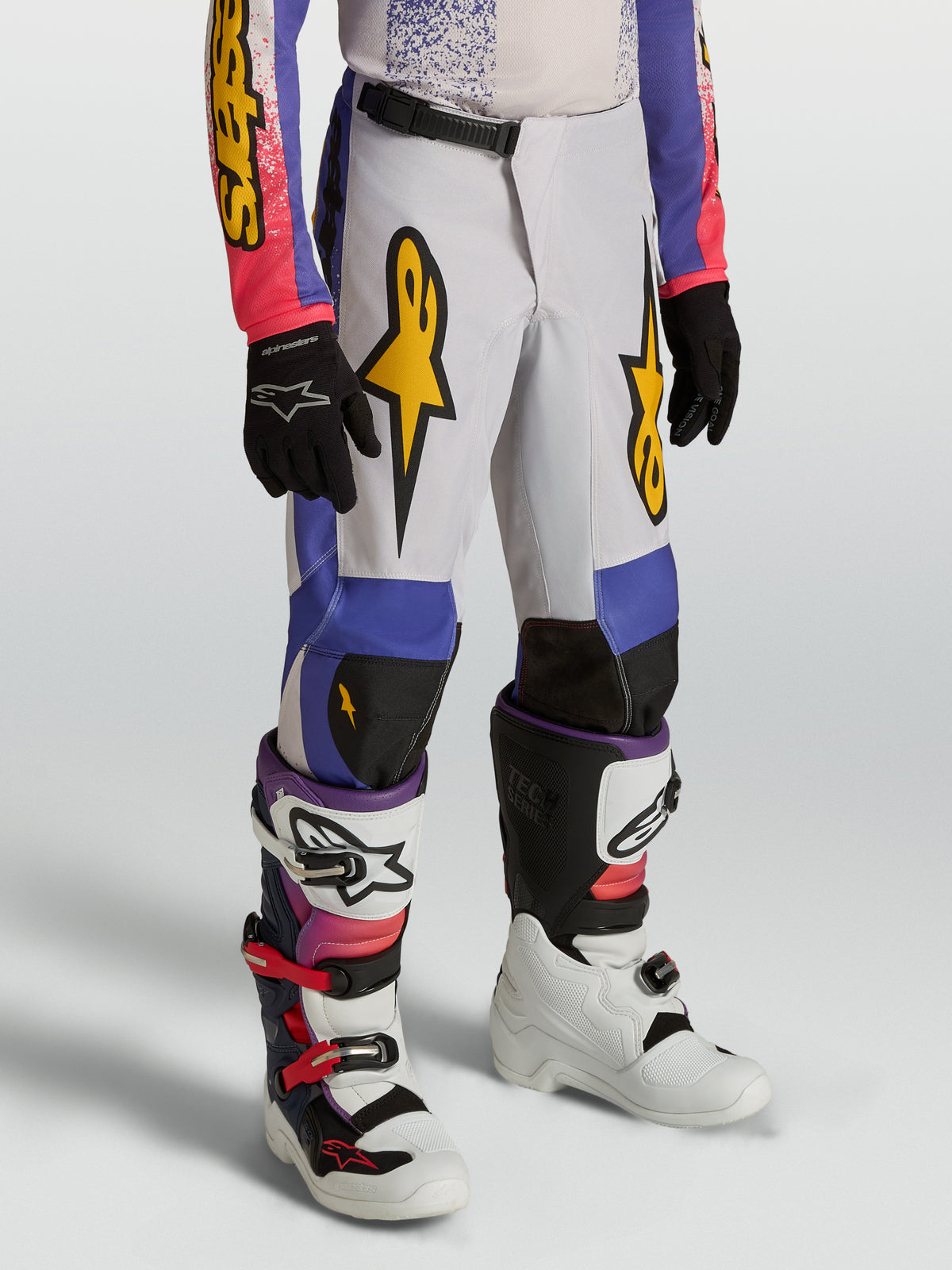 Pantalon Fluid Drag Junior Alpinestars, pantalon de motocross bleu et violet pour enfant, graphismes dorés et design précurvé.